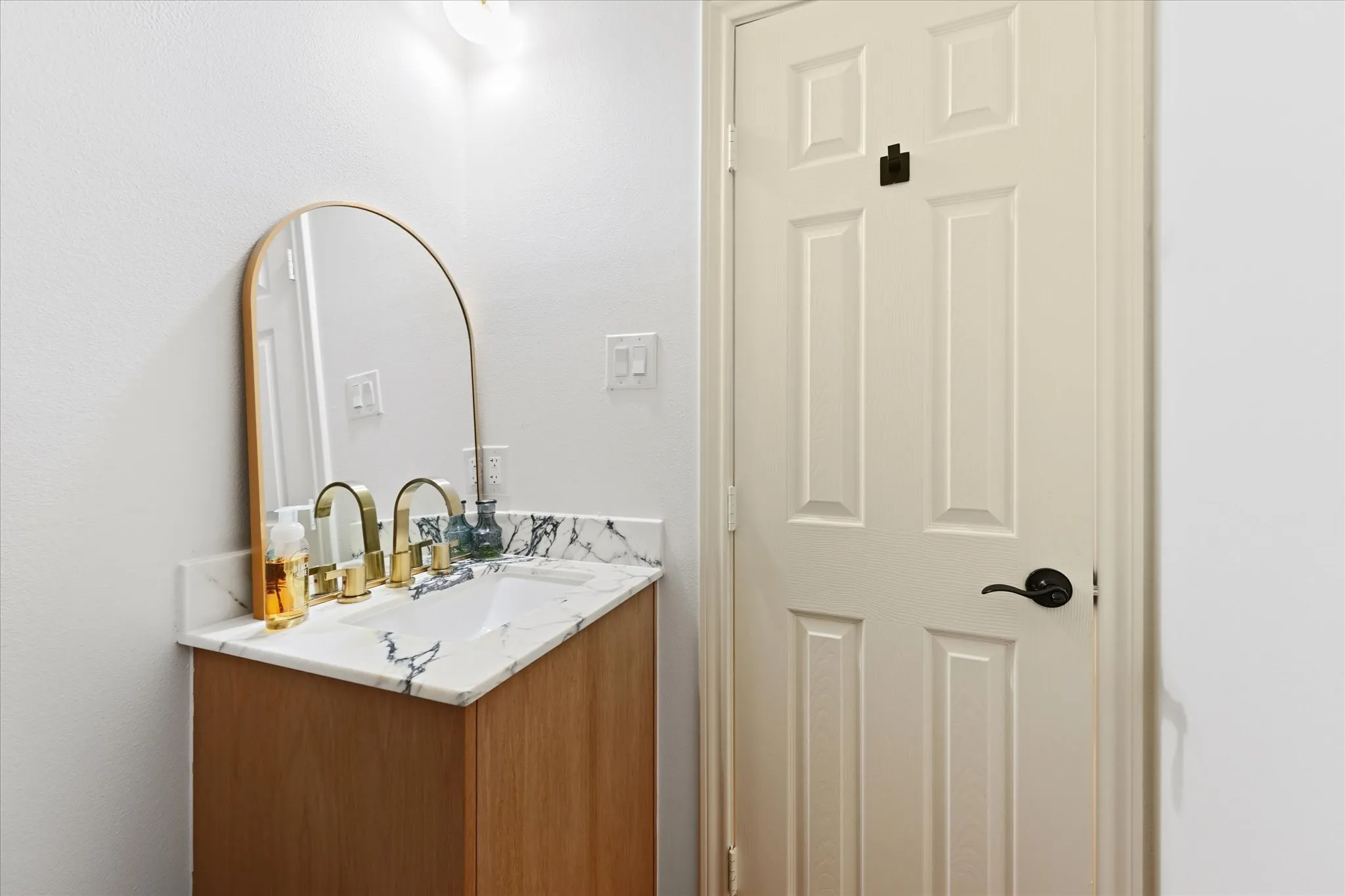 Wood-finish vanity with an integrated sink and light-colored countertop