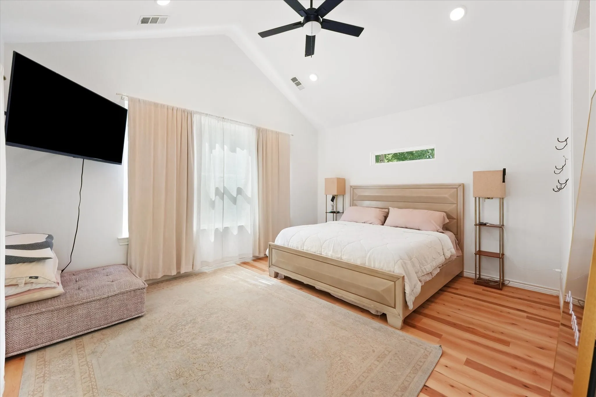 Vaulted ceiling with a ceiling fan, hardwood flooring, recessed lighting, and a horizontal window