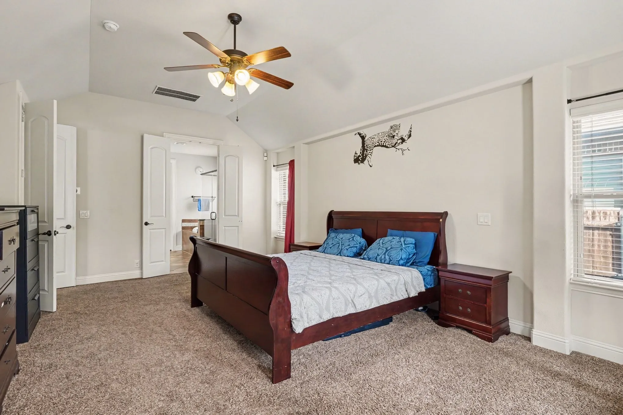 Vaulted ceiling, ceiling fan with integrated lighting, white paneled doors, window with blinds, and carpeted flooring