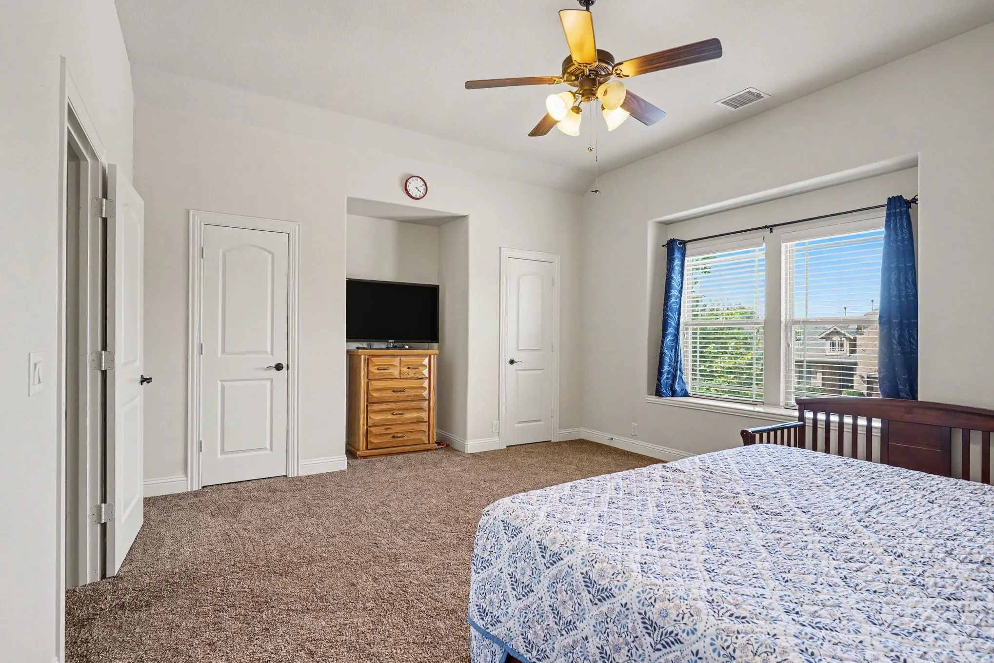 Vaulted ceiling with a ceiling fan, carpeted flooring, and a large window with blinds