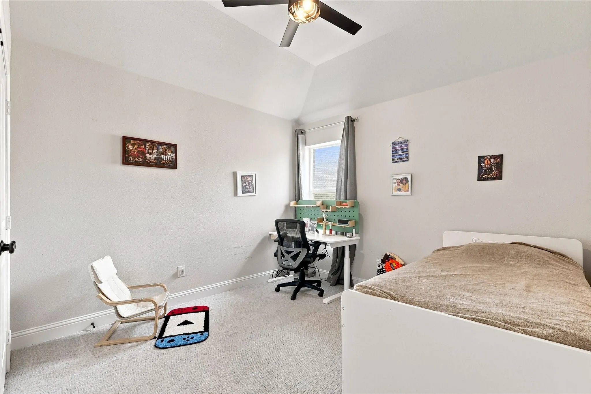 Vaulted ceiling with an attached ceiling fan, neutral wall paint, and plush carpeting