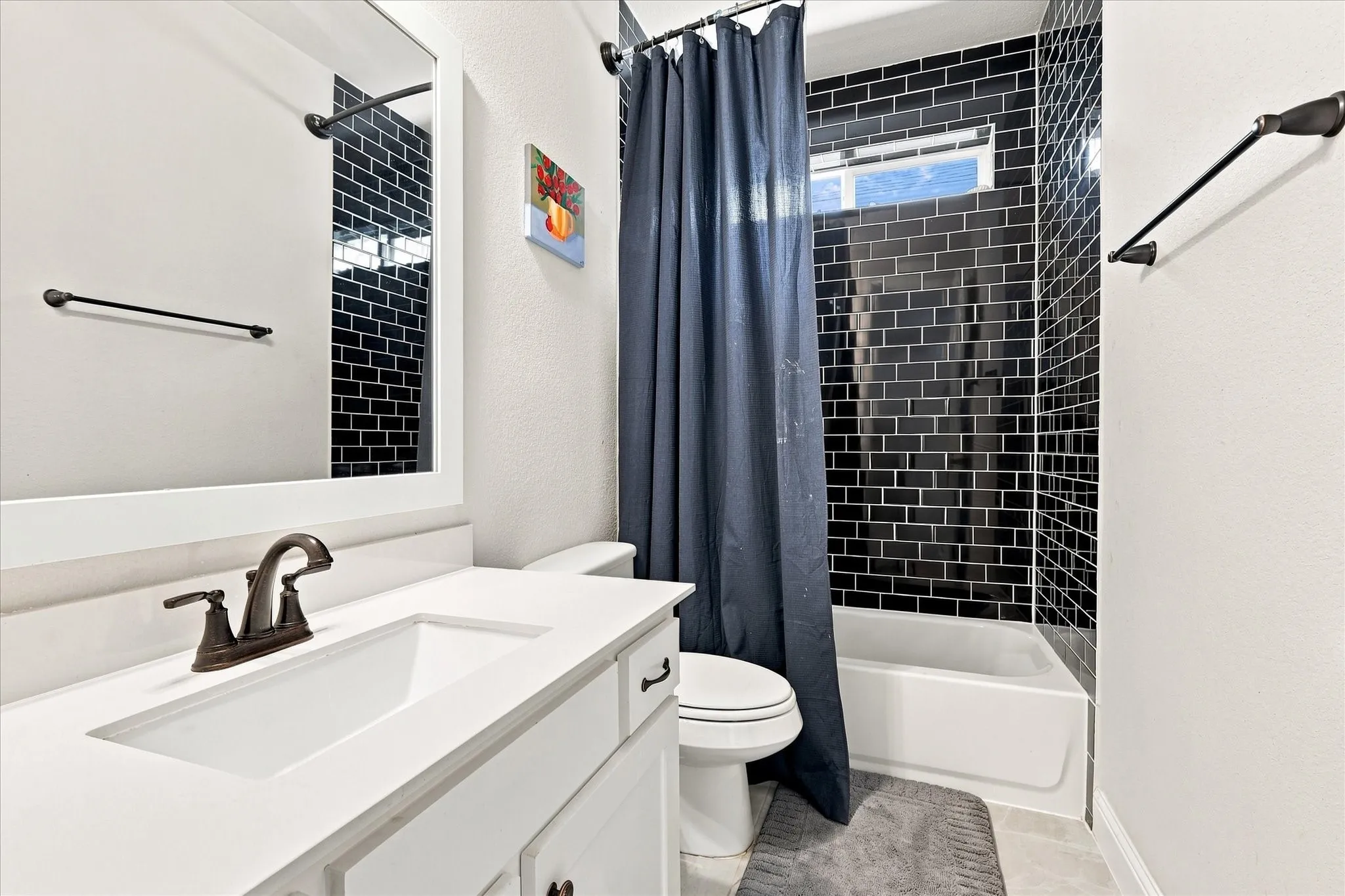Modern bathroom featuring a white quartz countertop with undermount sink, oil-rubbed bronze faucet, and generous storage cabinetry