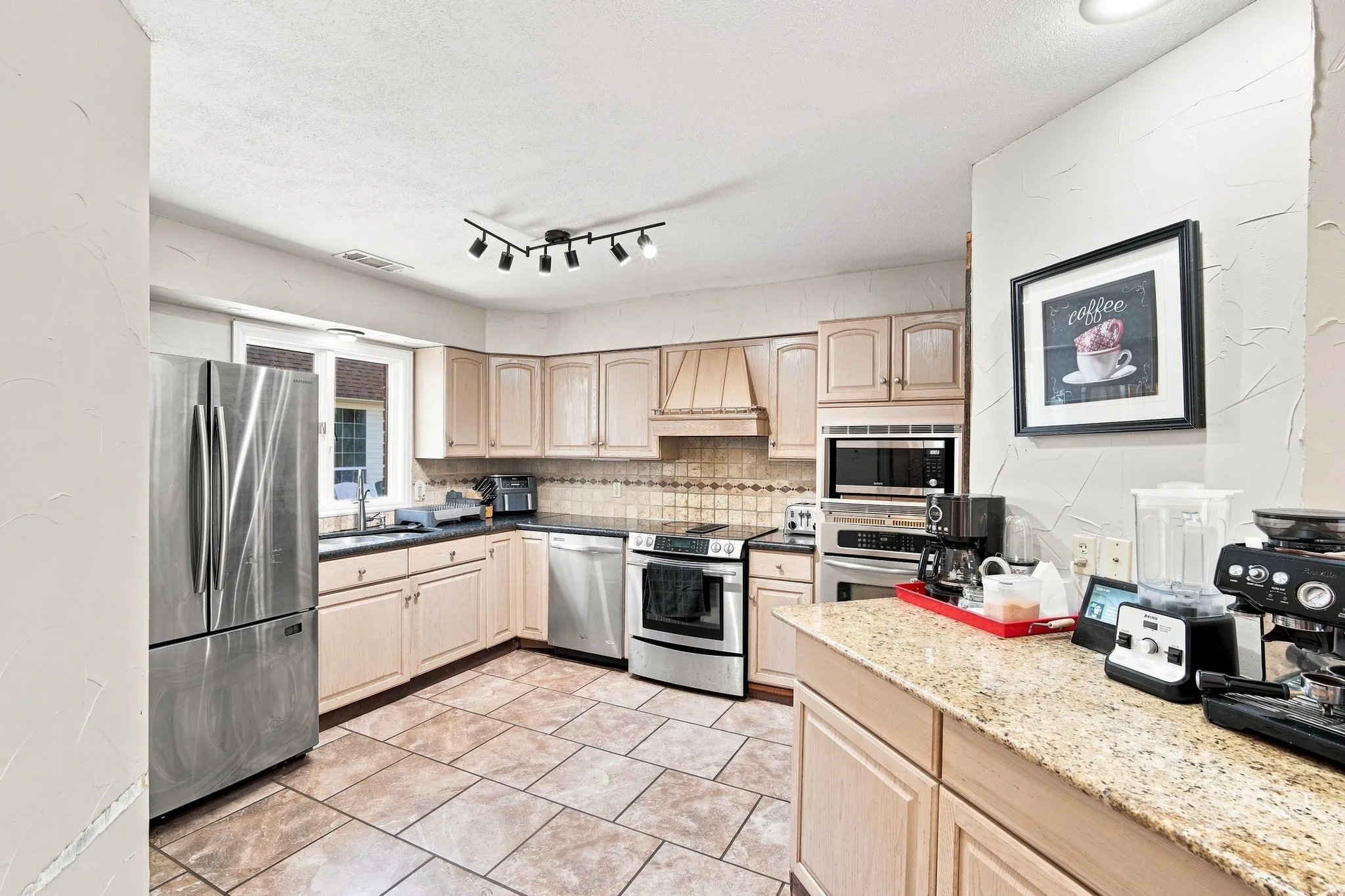 Stainless appliances and coffee bar with granite countertops