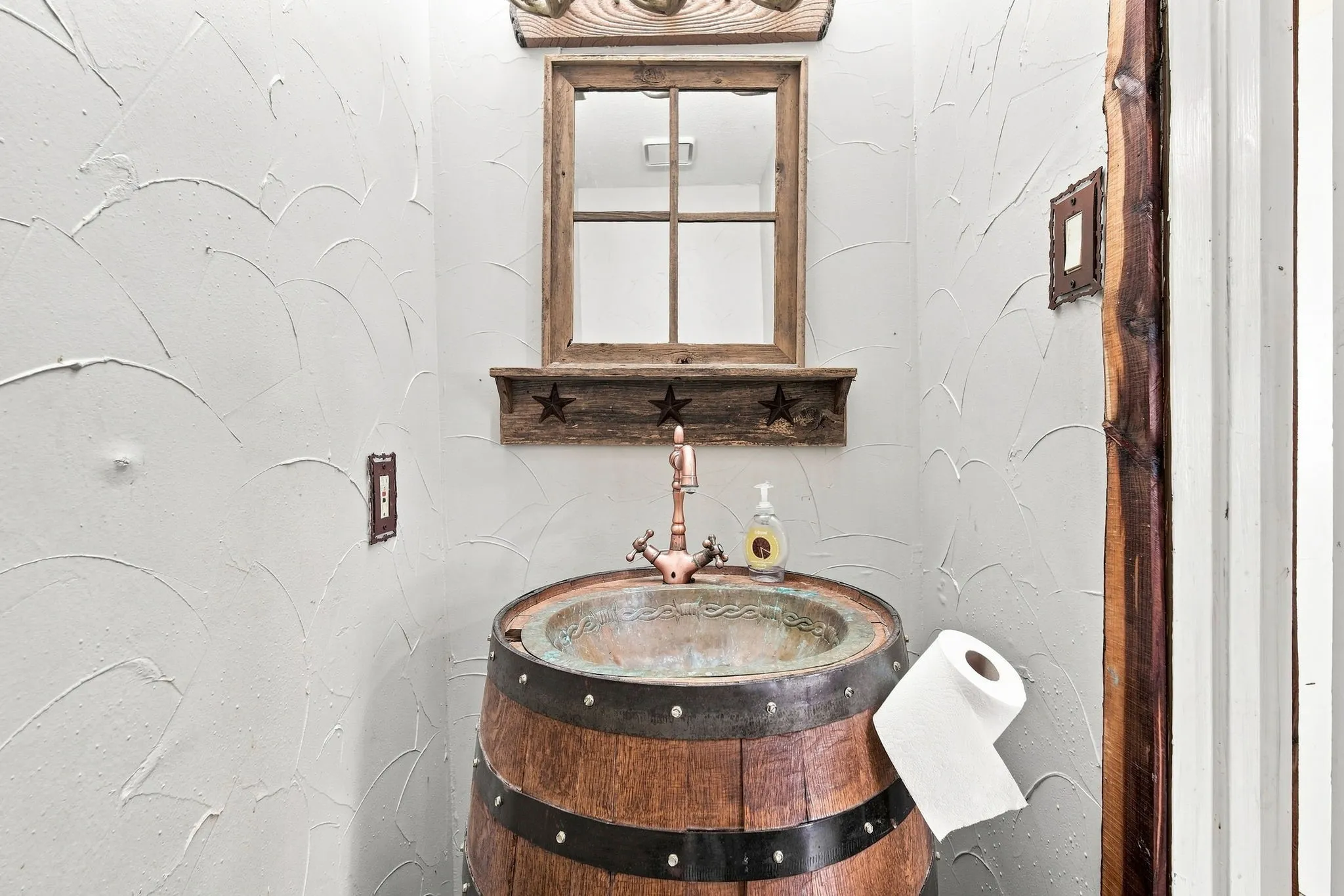 powder room by living room showcasing barrel sink