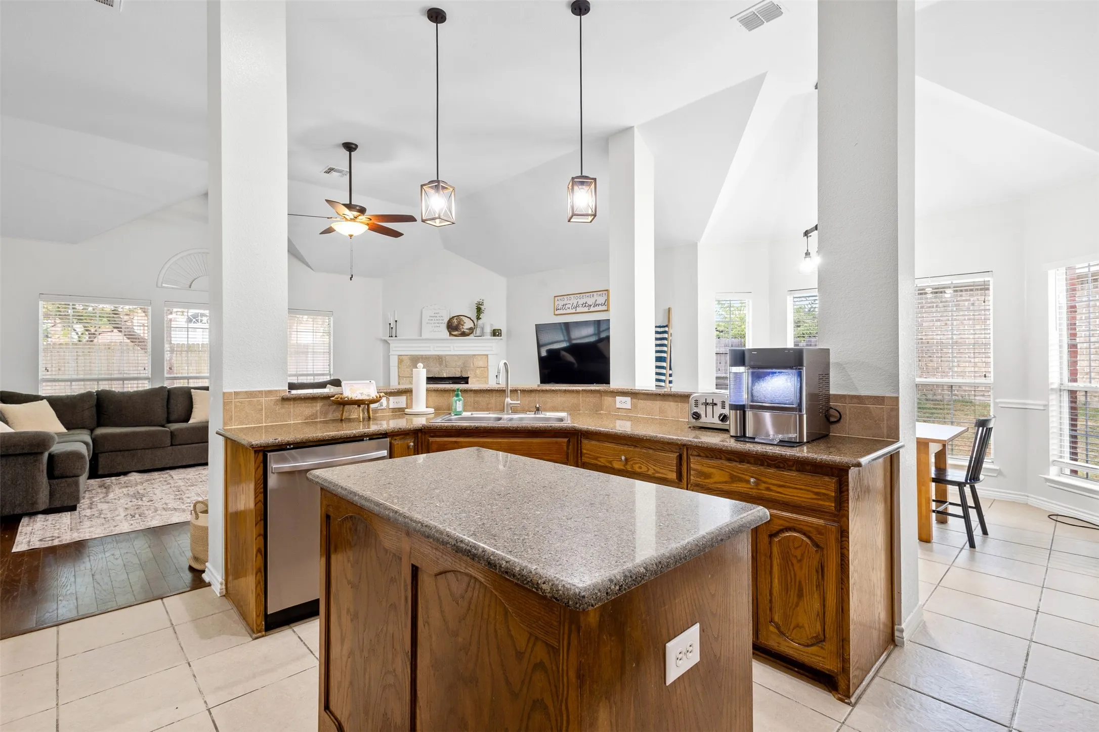 Kitchen featuring wood cabinetry, light countertops, and a stainless steel dishwasher