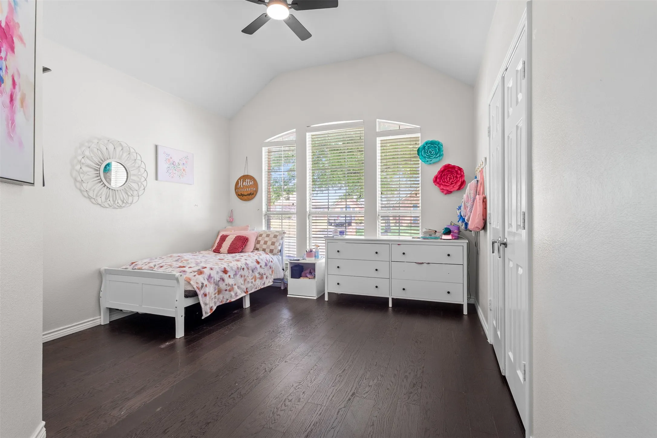 Vaulted ceiling with a ceiling fan, dark wood-finish flooring, and multiple arched windows with blinds
