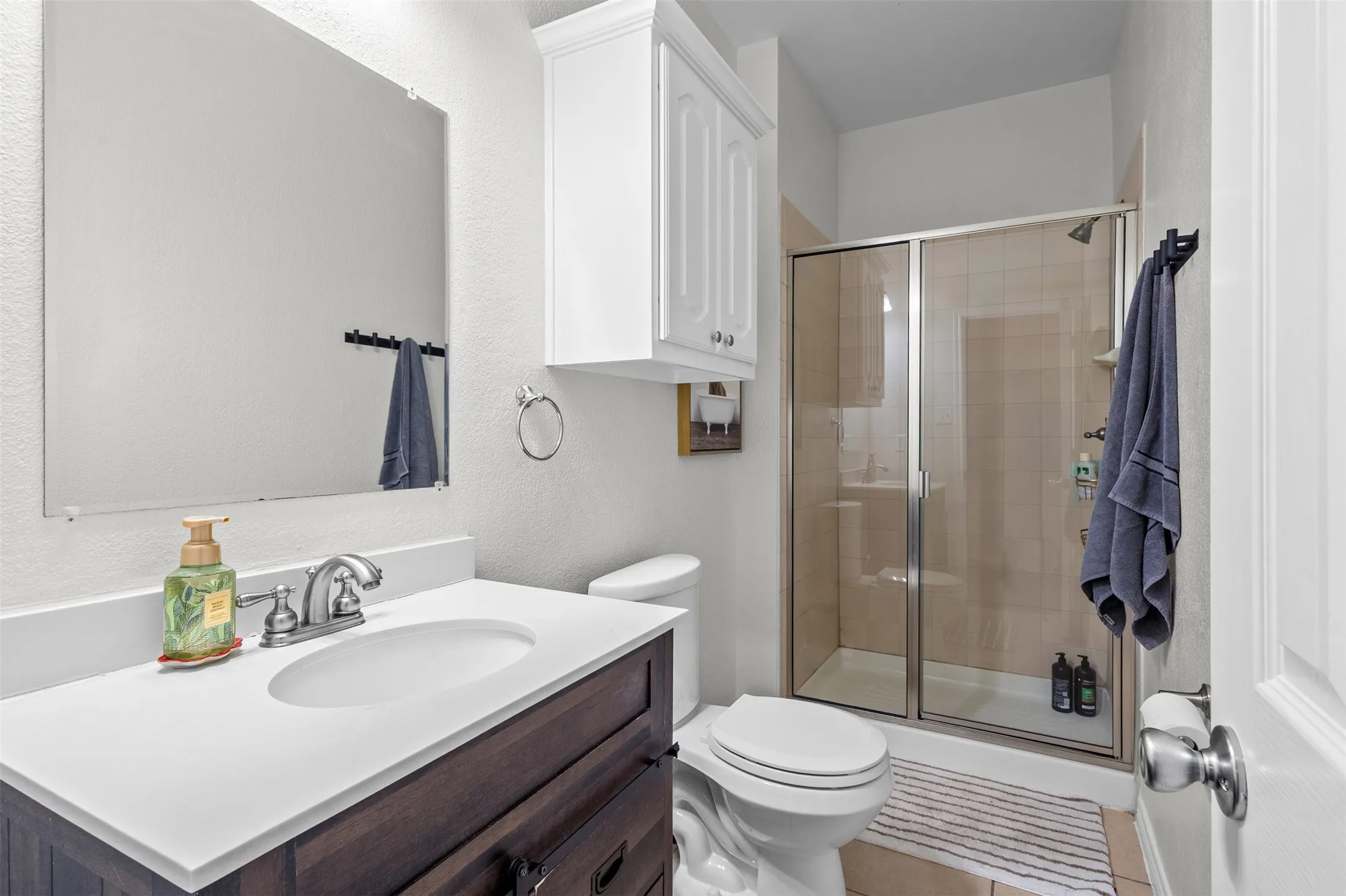 Vanity with a white countertop and integrated sink