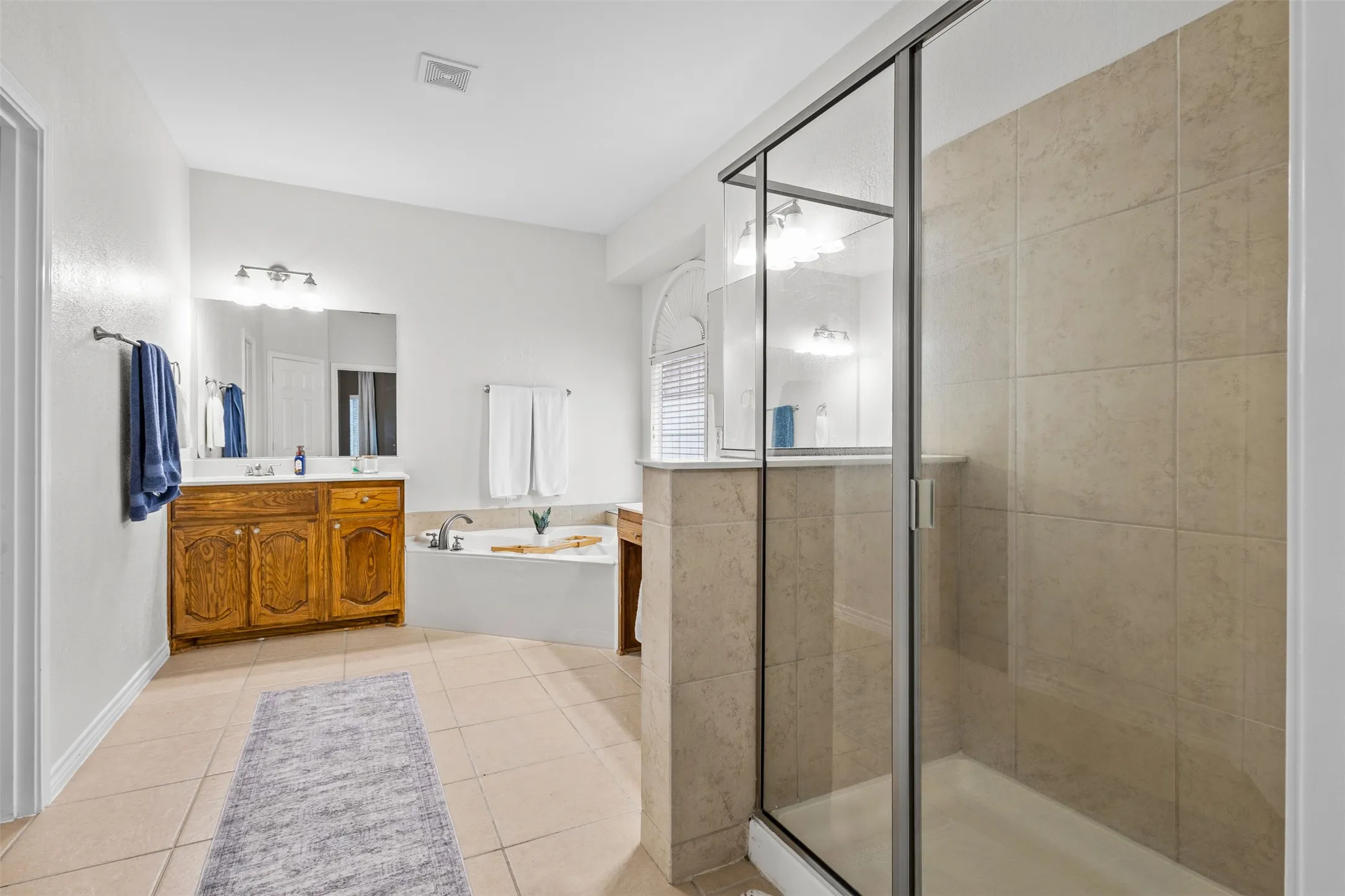Walk-in shower with clear glass enclosure and tiled walls