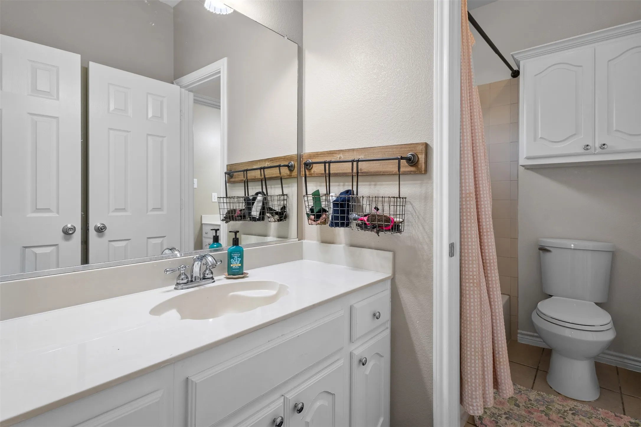 White vanity with an integrated sink, polished chrome faucet, and a large wall-mounted mirror