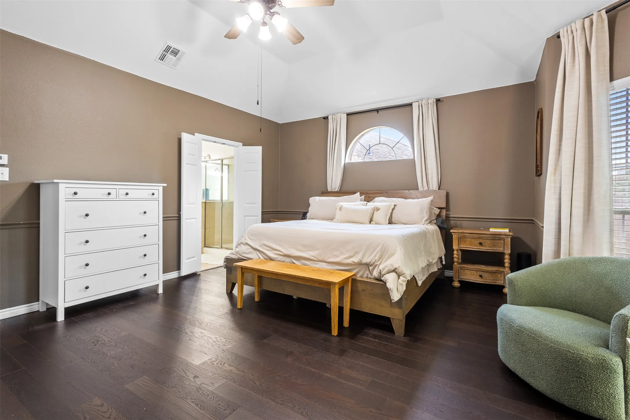 Vaulted ceiling featuring a ceiling fan, dark wood-finish flooring, and an arched window with blinds