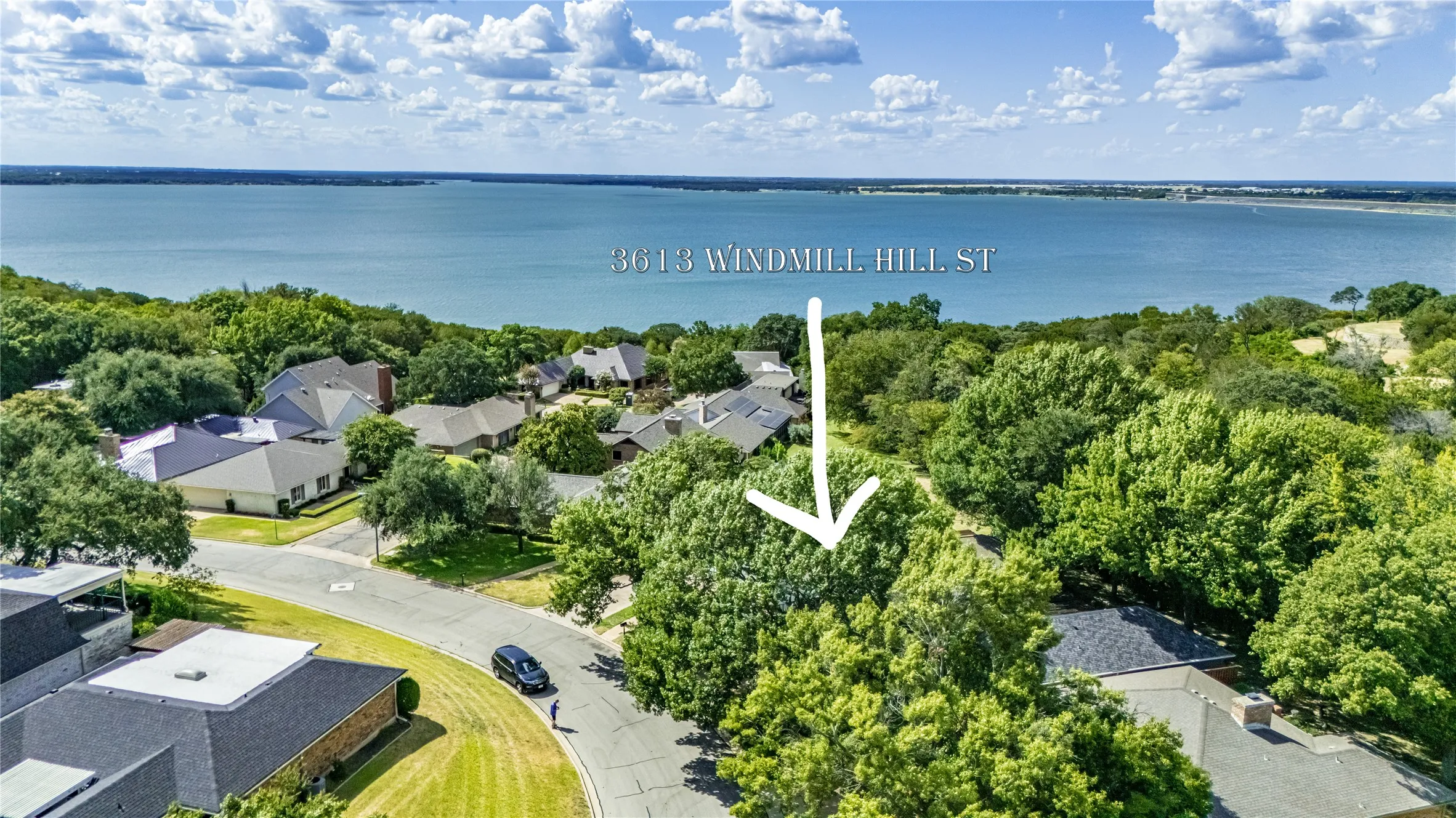 Aerial perspective of this waterfront property on Normandy Hill Street, showcasing mature landscaping, manicured lawn, and direct water access with expansive bay vistas