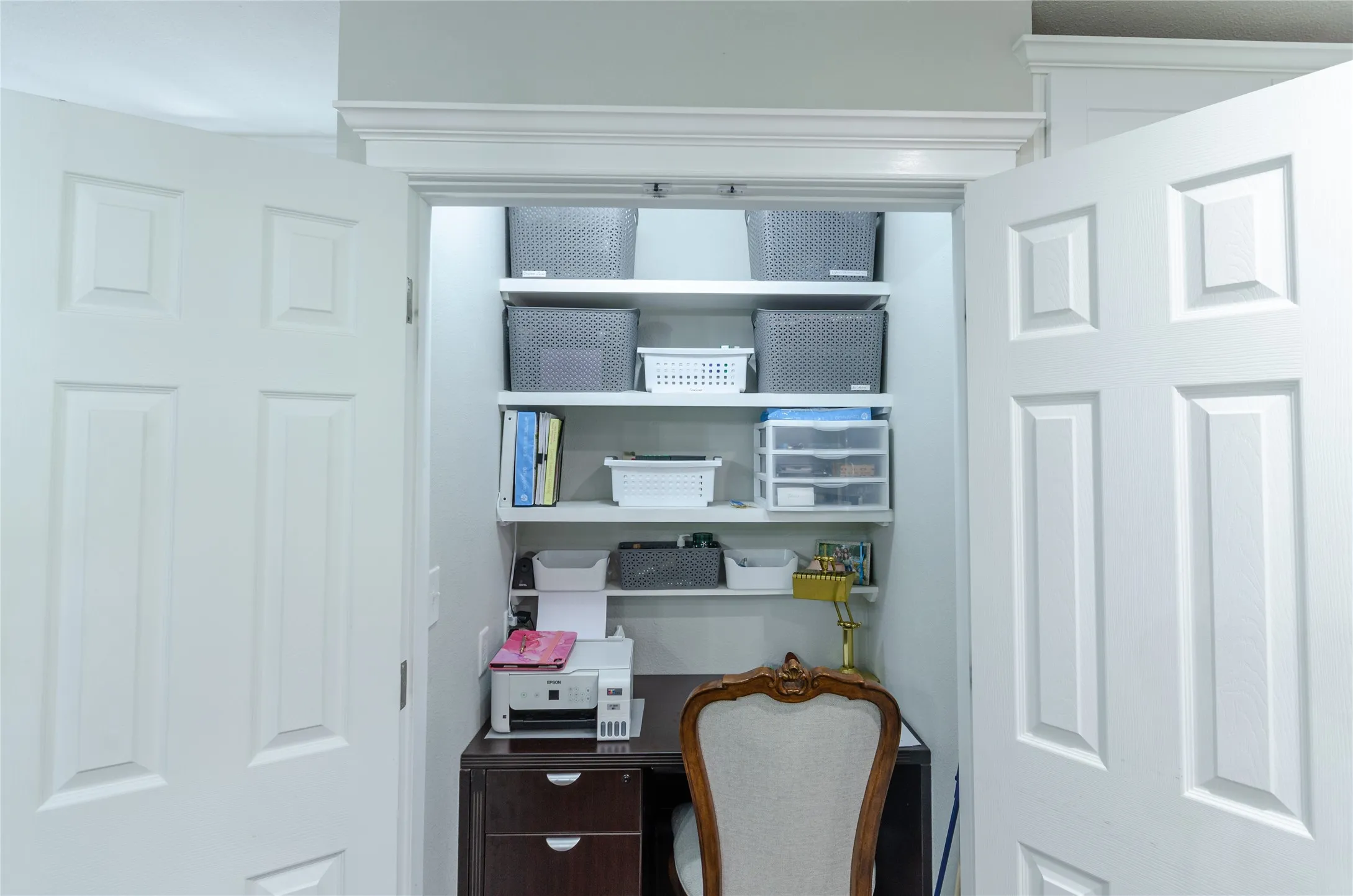 Built-in shelving, dark wood-finish desk, and white paneled doors