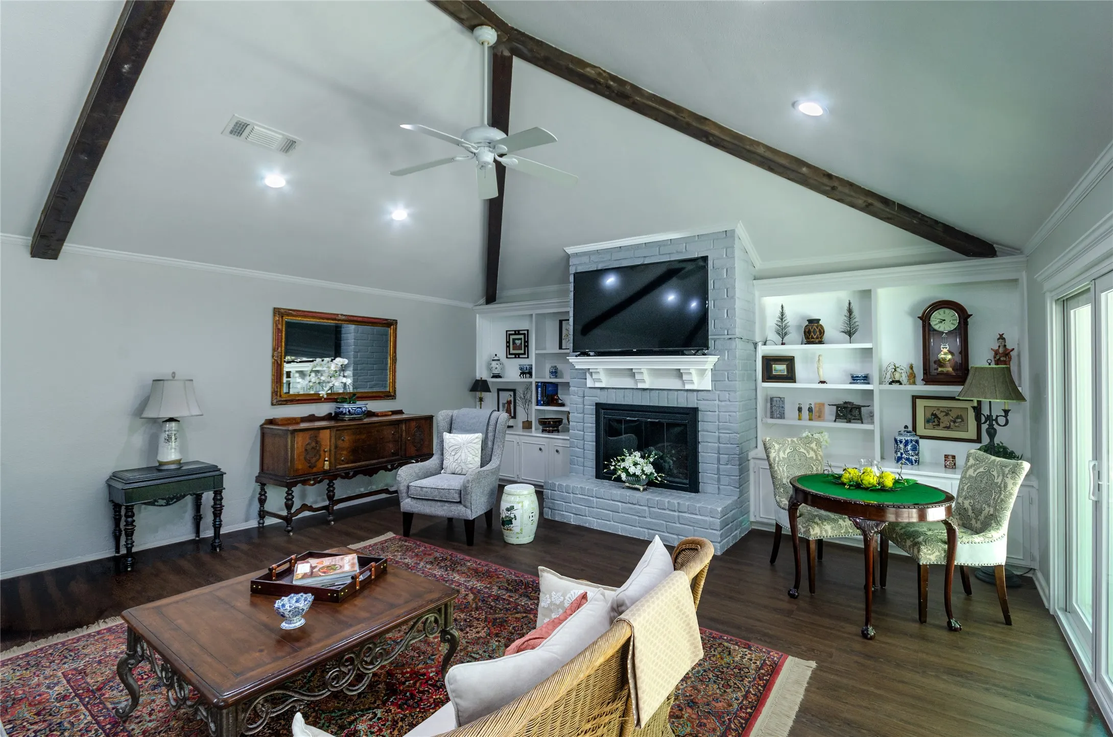 Vaulted ceiling with exposed wood beams, recessed lighting, and a ceiling fan