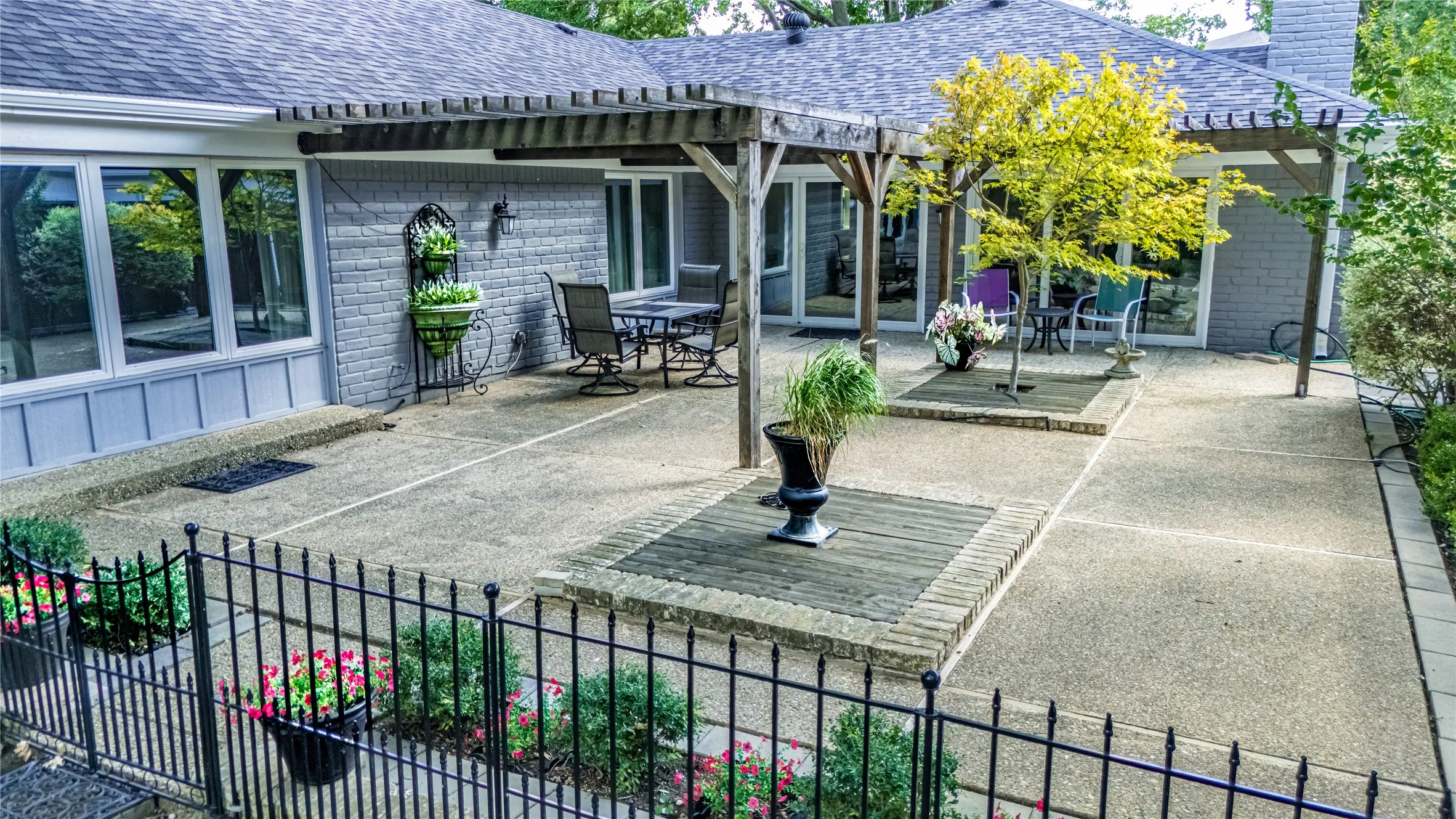 Expansive outdoor patio with concrete surfacing and decorative brick accents