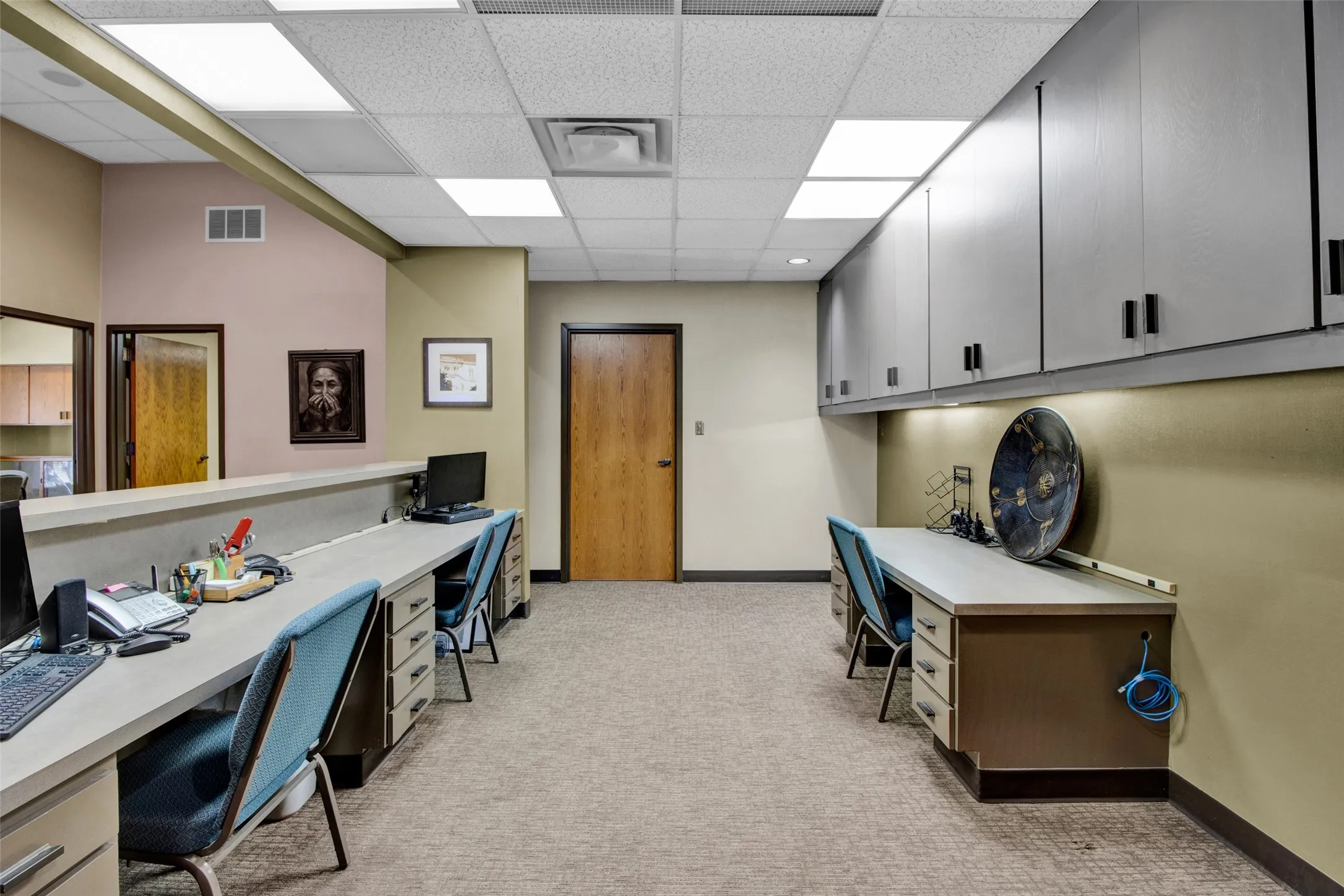 Recessed lighting, drop ceiling, wall-mounted cabinetry, built-in desks, and carpeted flooring
