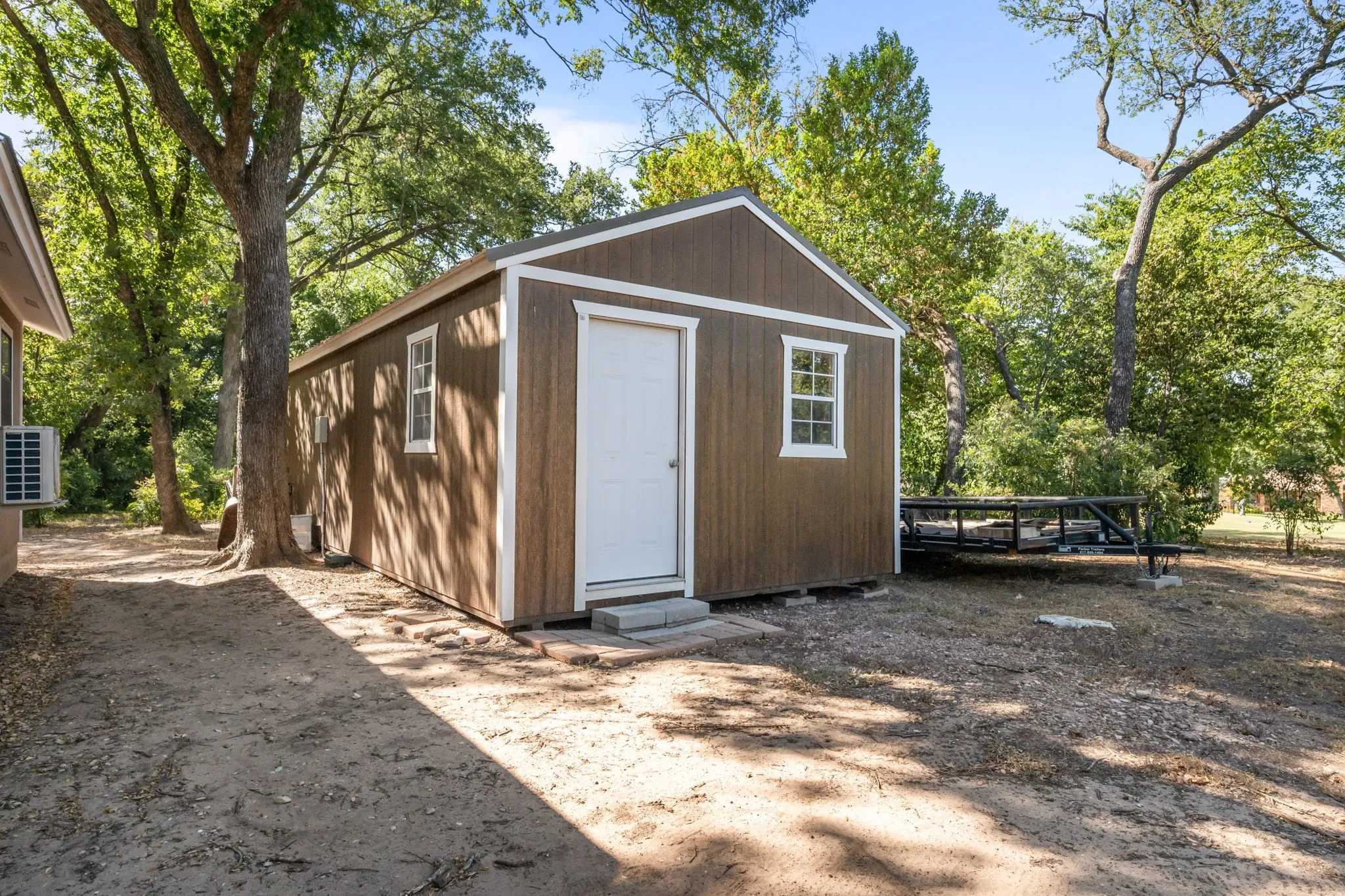 14x32 building with wood-finish siding, white trim, and a side-hinged entry door