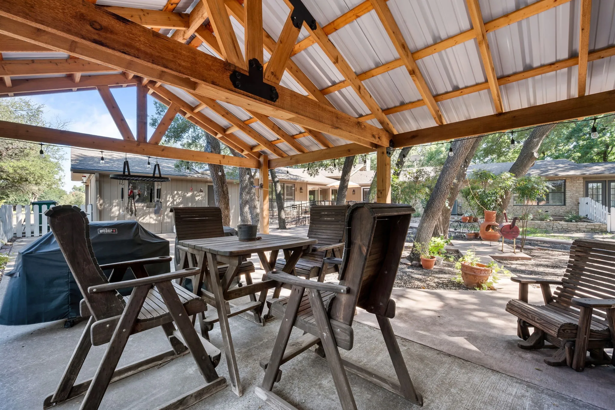 Covered concrete patio with exposed wood beam ceiling and metal roof