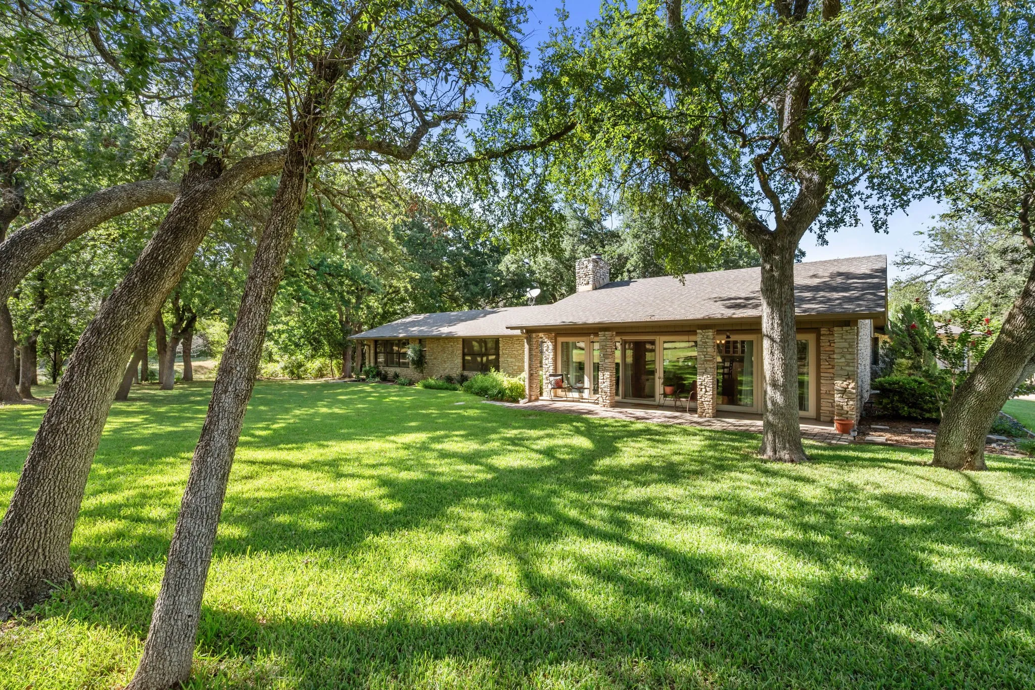 Expansive green lawn framed by mature trees