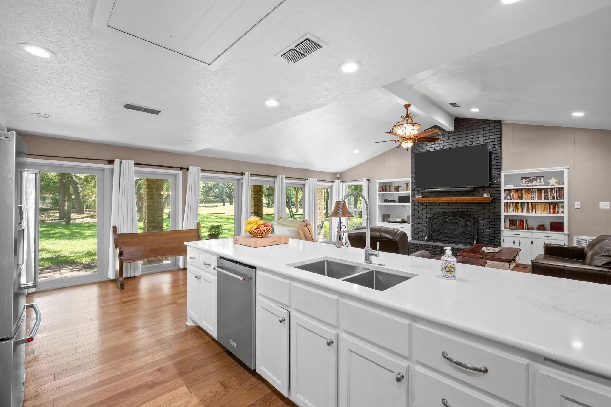 Kitchen island with dual stainless steel sinks, white cabinetry, and a light-colored countertop