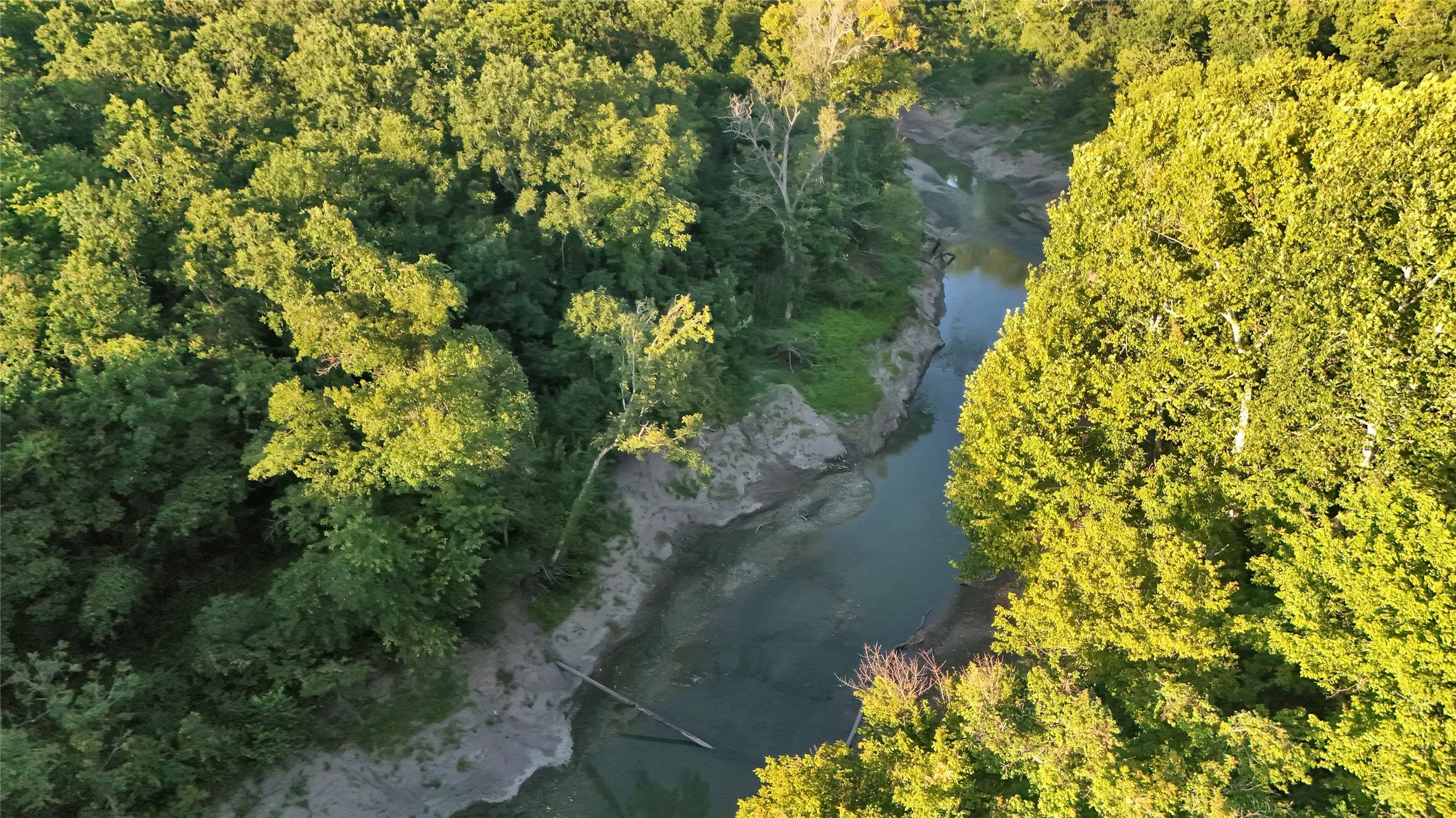 Wooded riverfront property featuring a winding waterway and dense tree coverage