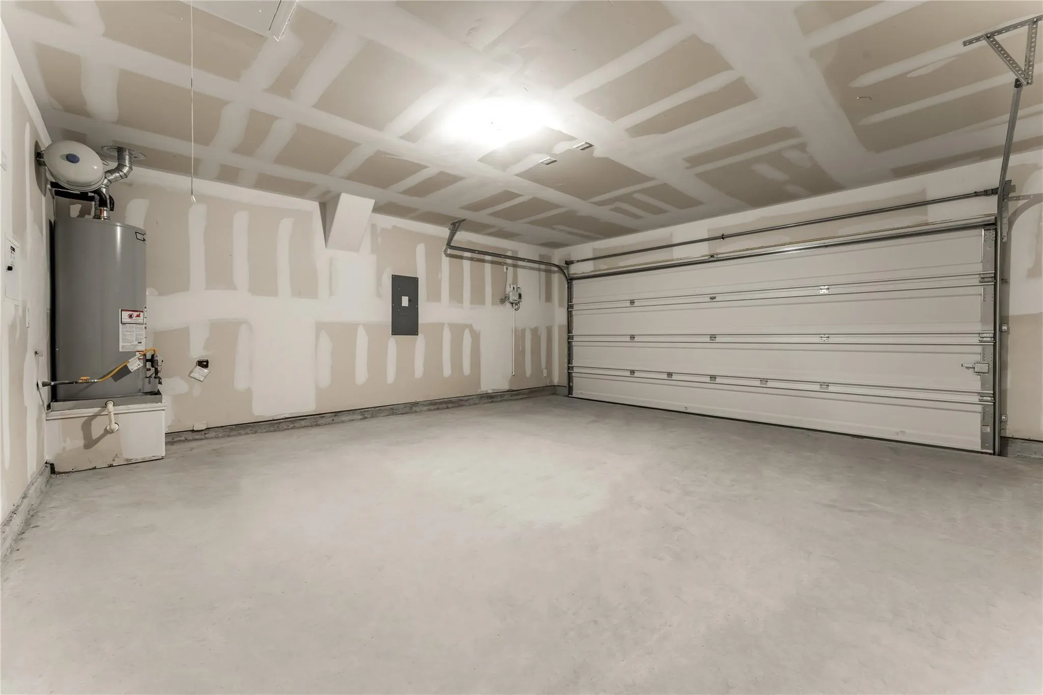 Garage with gas water heater and electric panel
