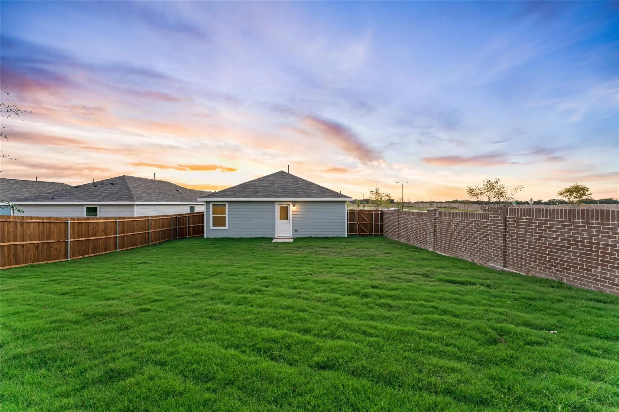 Yard at dusk featuring a fenced backyard