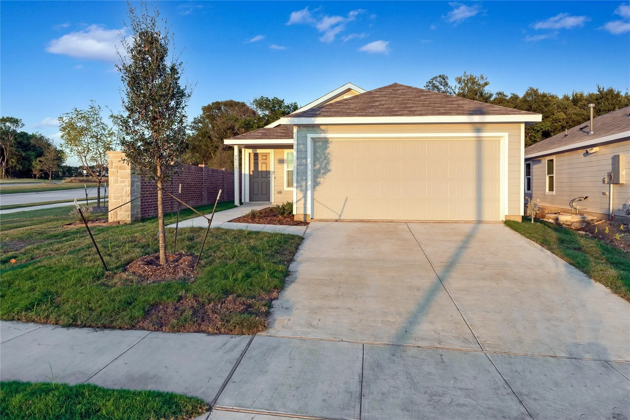 Ranch-style home featuring concrete driveway and roof with shingles