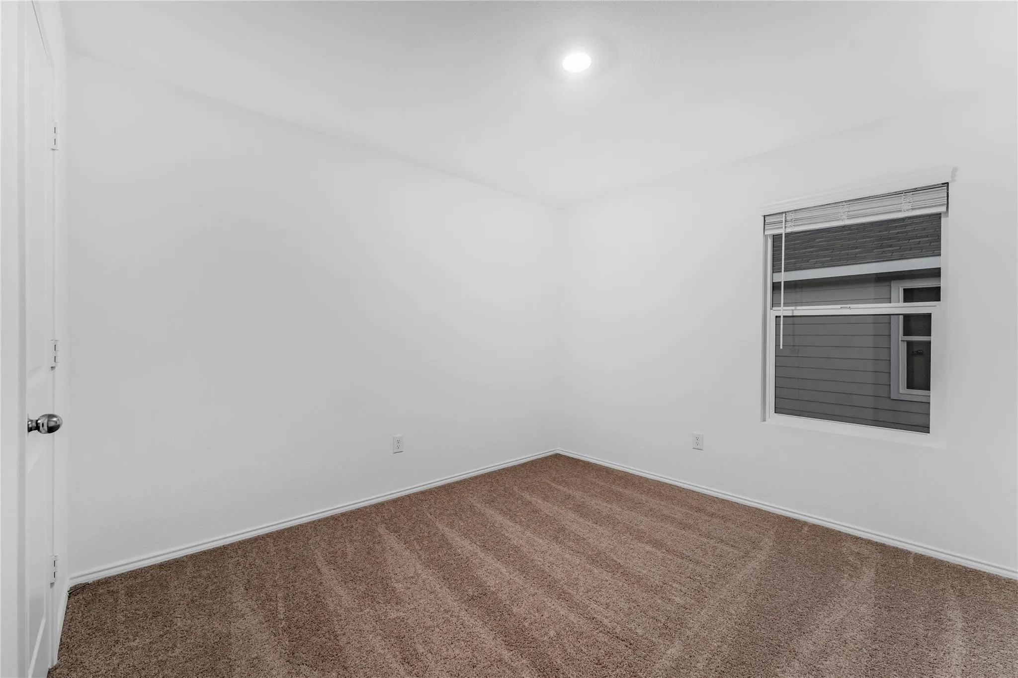Empty room featuring carpet flooring and baseboards