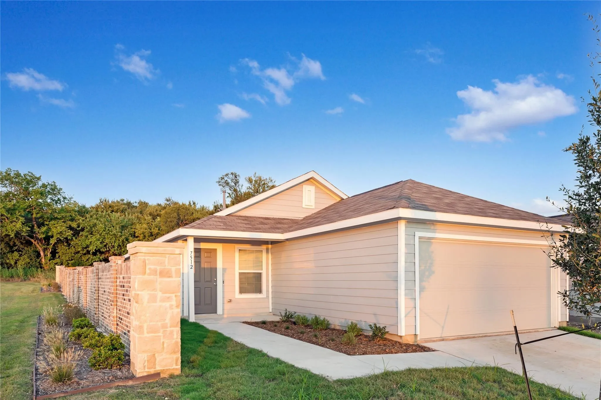 View of front of property featuring a garage and concrete driveway