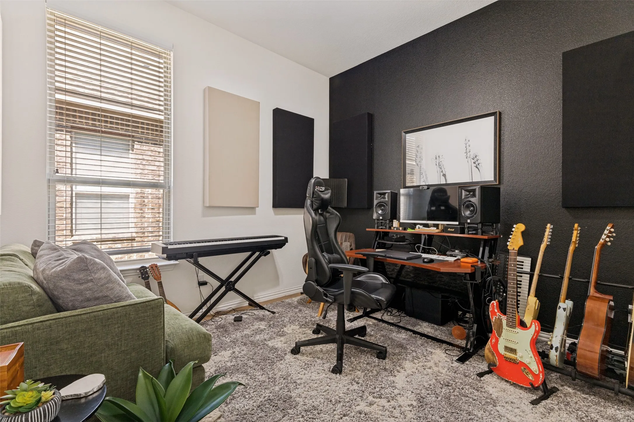 Textured accent wall, acoustic wall panels, window with blinds, and light-toned carpet
