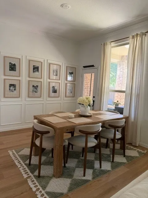 Recessed ceiling lighting, crown molding, wood-finish flooring, wainscoting, and a full-light exterior door