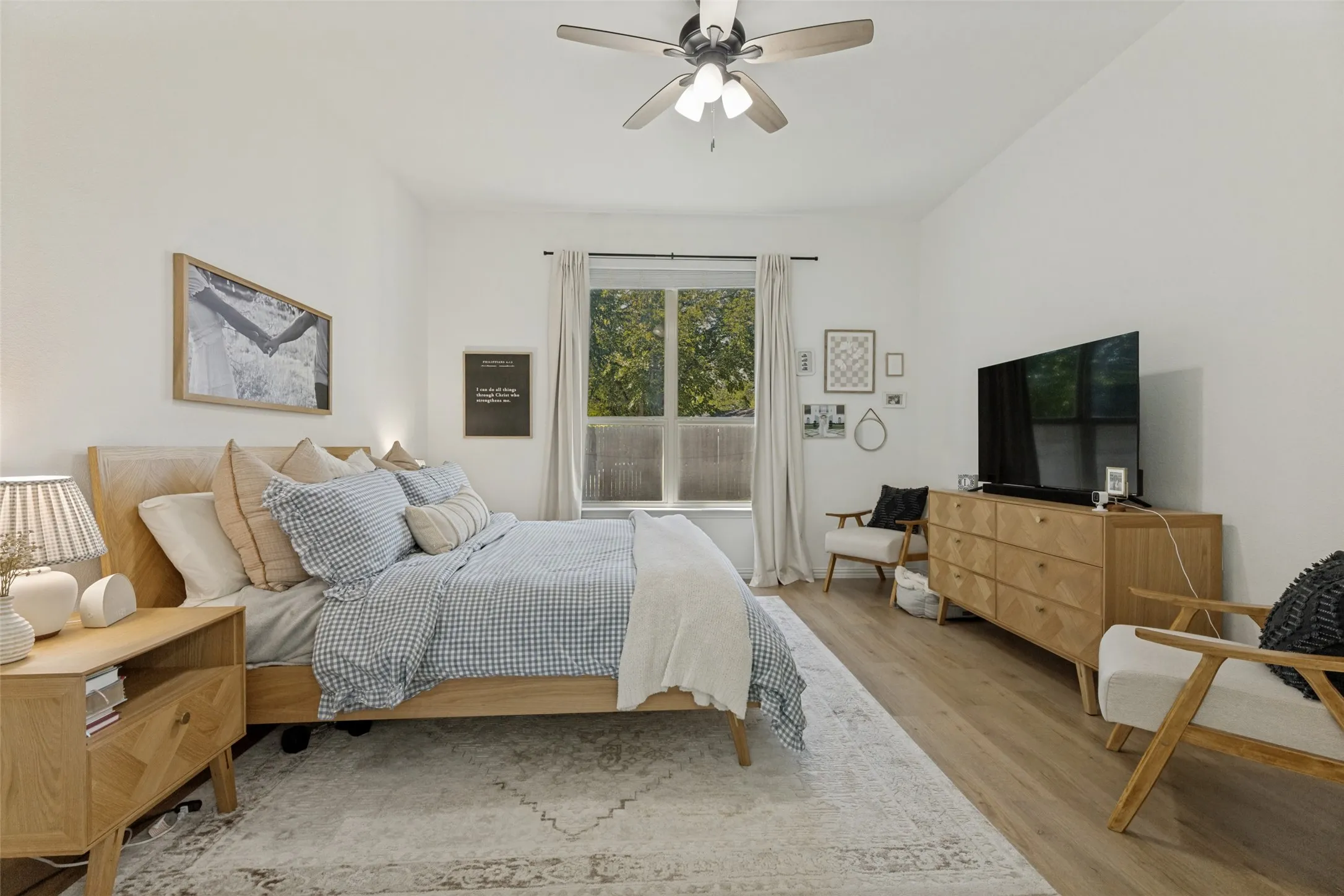 Wood-finish flooring, ceiling fan with integrated lighting, window with drapes, and recessed lighting