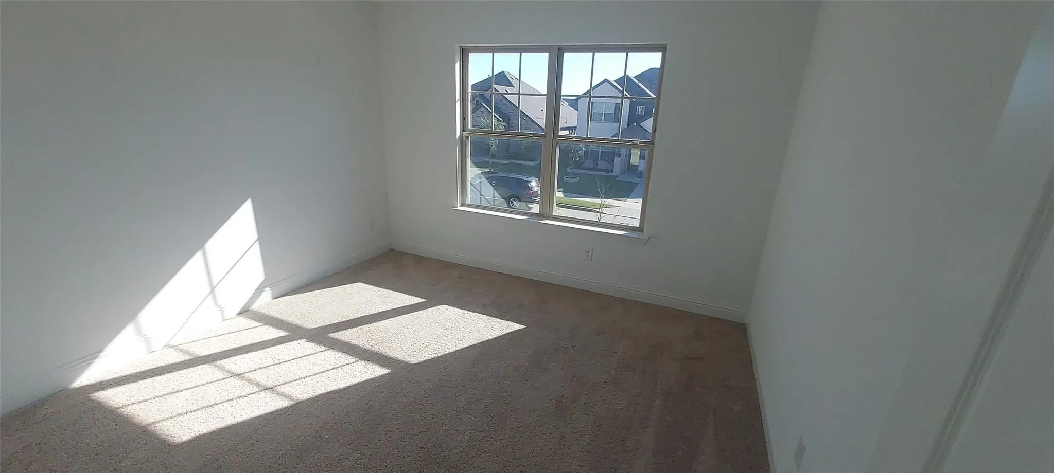 Neutral tone wall finishes, carpeting, and a multi-pane window