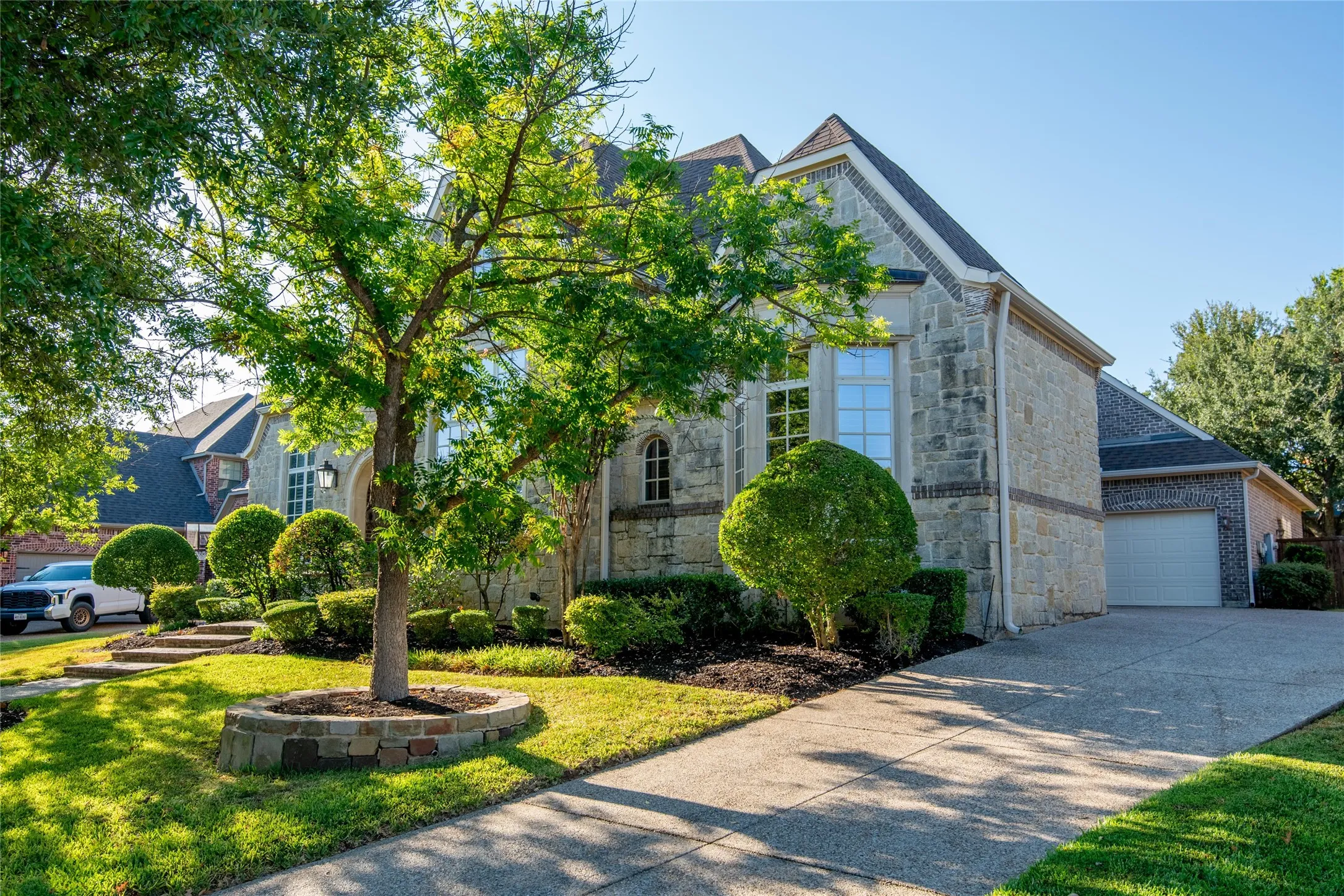 Another view highlights the home’s substantial architecture, mature landscaping and generous driveway approach.