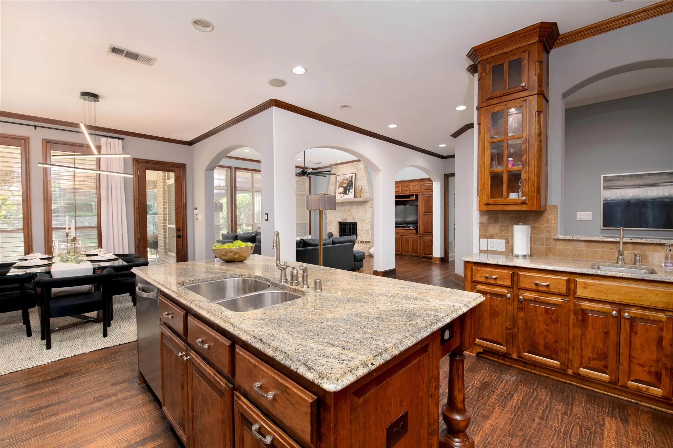 The chef’s kitchen centers around a large island with generous prep and serving space, surrounded by rich custom cabinetry and extensive millwork.