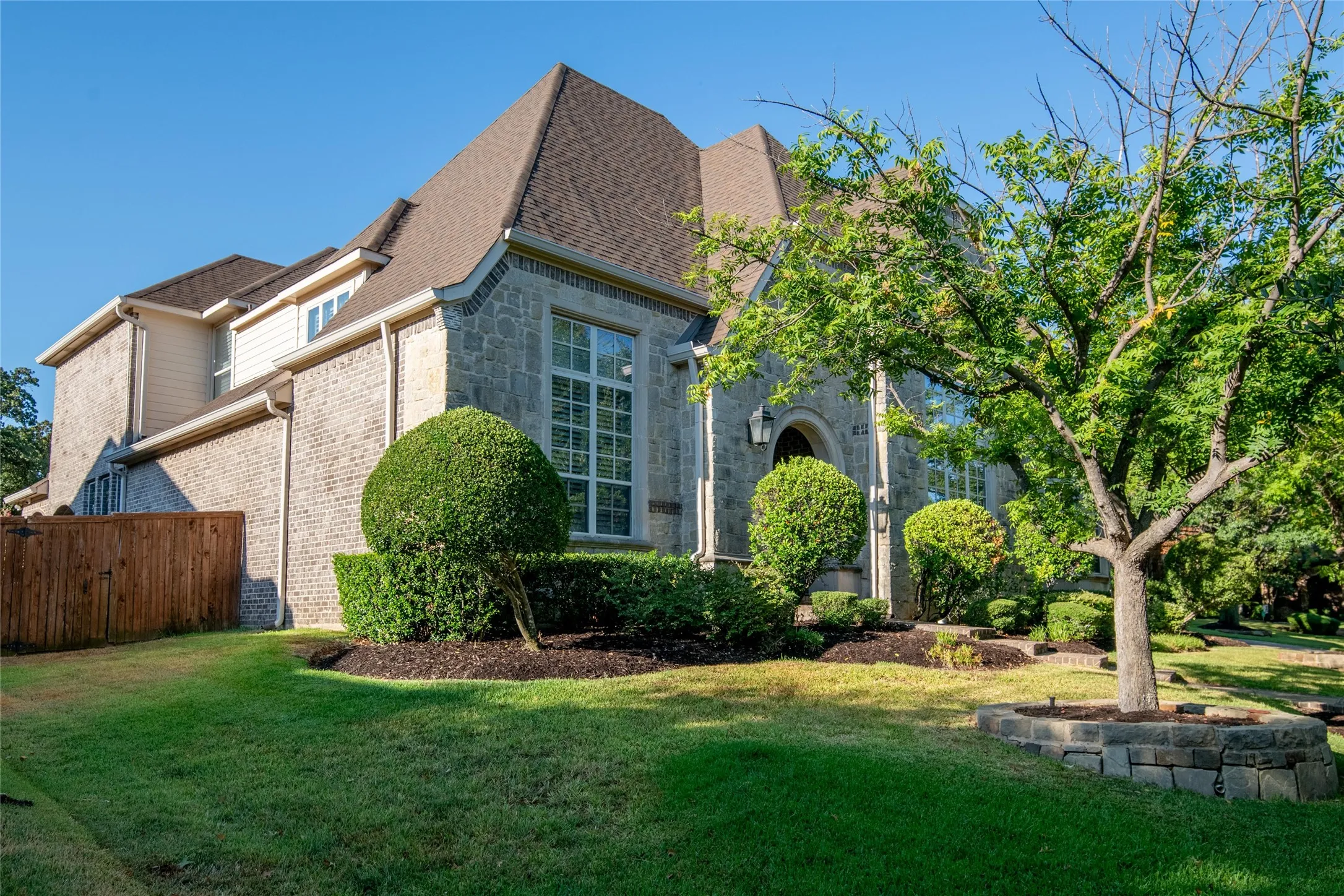 A final exterior view showcases the home’s substantial custom architecture, beautiful landscaping and desirable setting within Bridlewood.