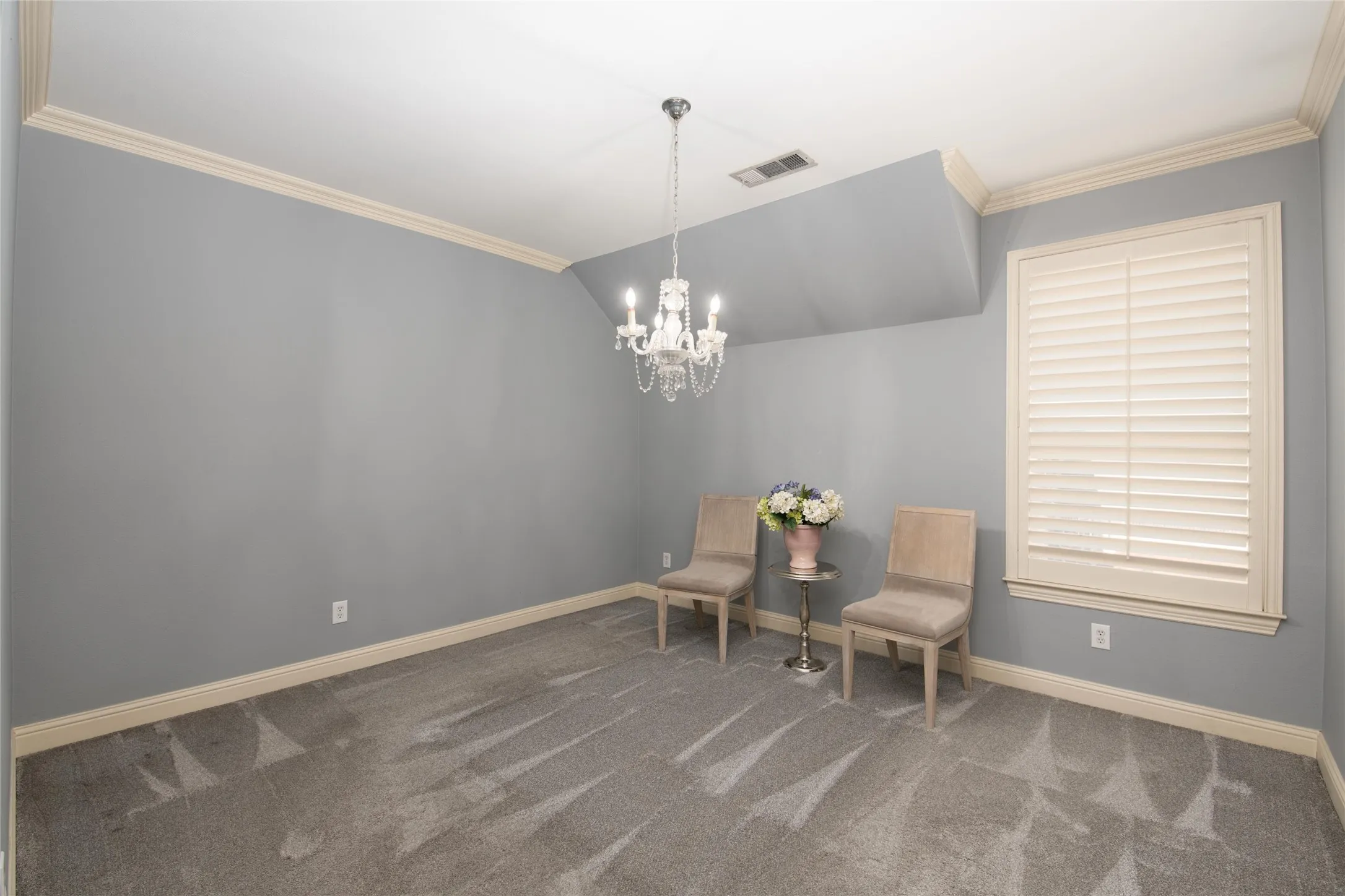Another spacious secondary bedroom features crown molding, plantation shutters and the generous proportions found throughout the home.