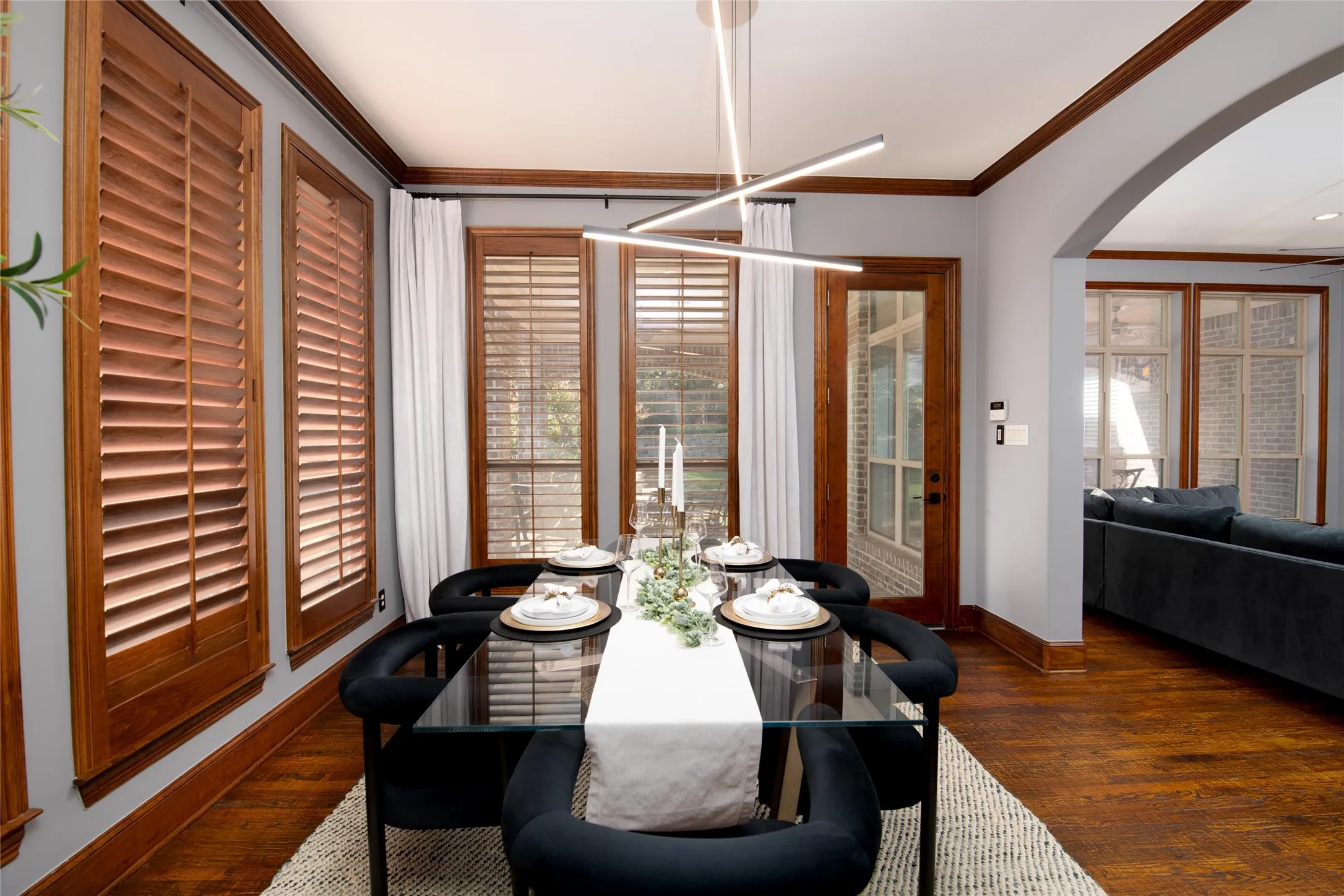 The adjoining breakfast area is bright and inviting, with walls of windows, plantation shutters and direct access to the outdoor living space.