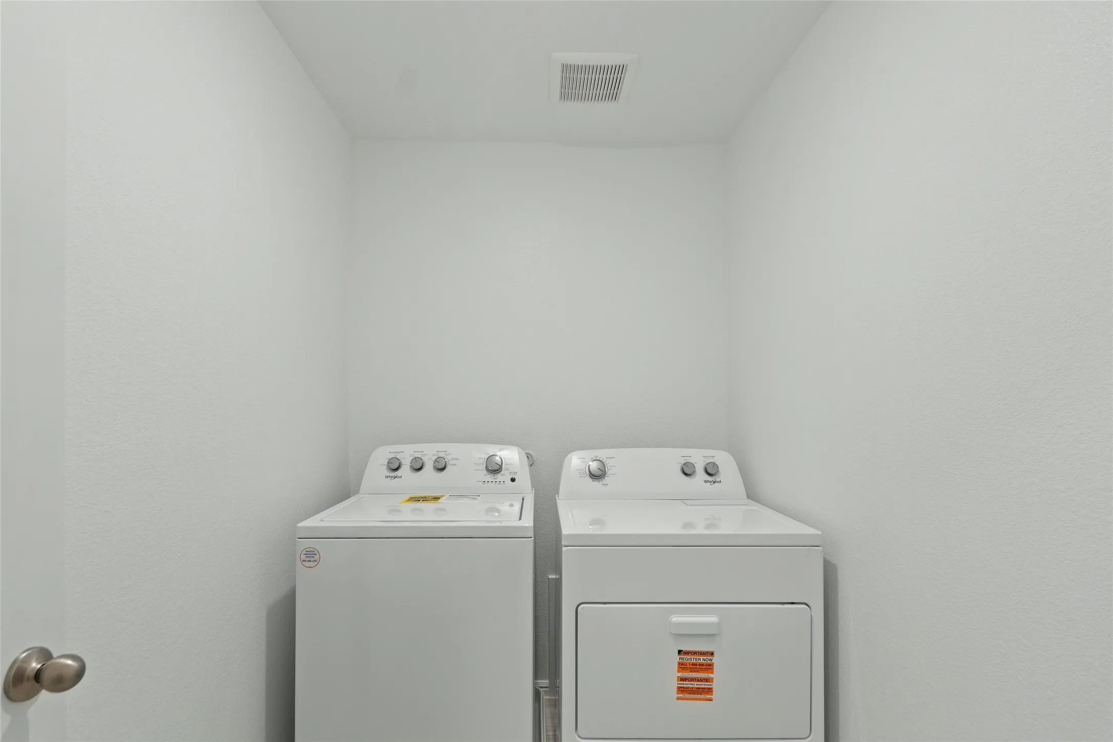 Clothes washing area featuring washer and dryer, visible vents, and laundry area