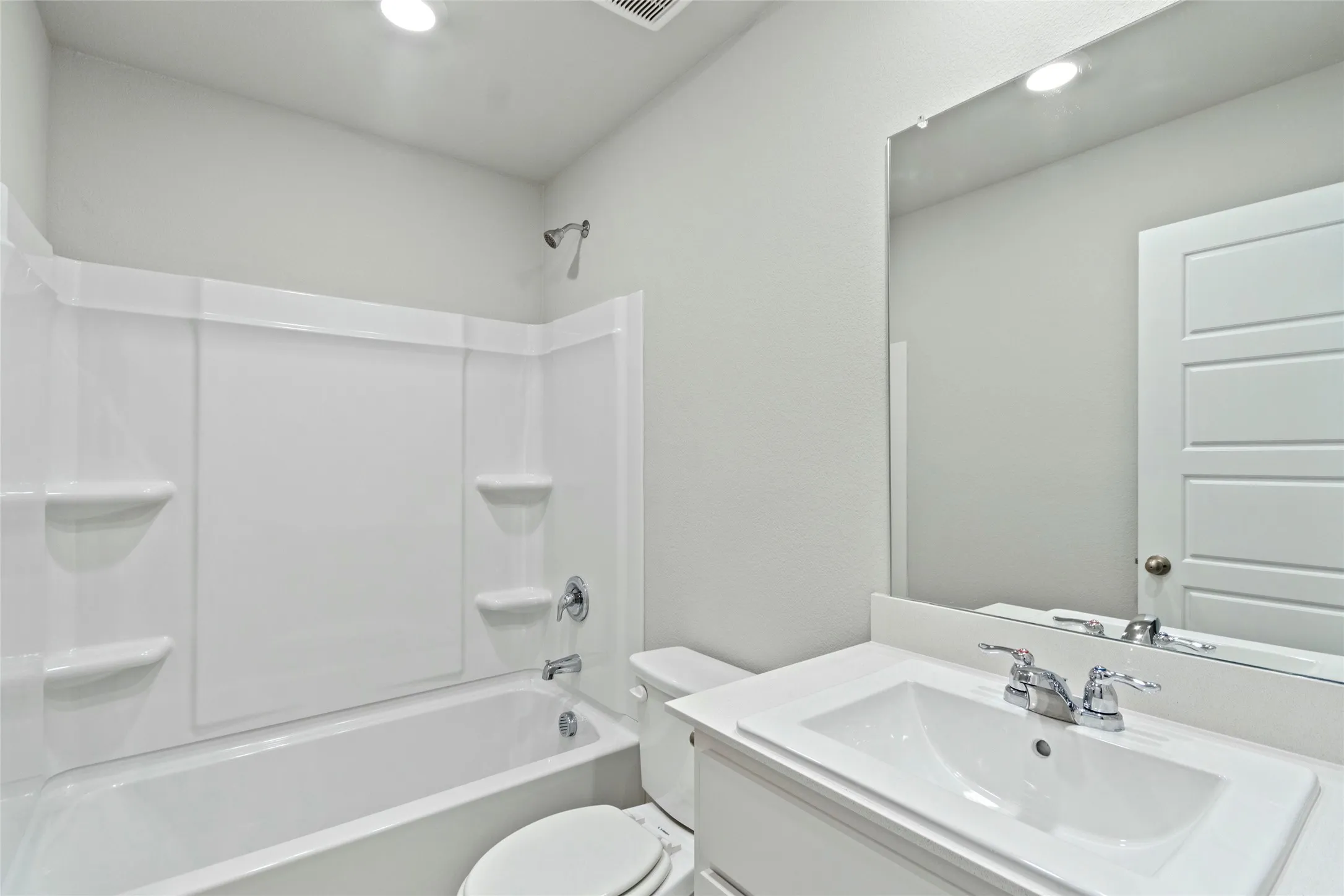 Bathroom with recessed lighting, vanity,  shower combination, and toilet
