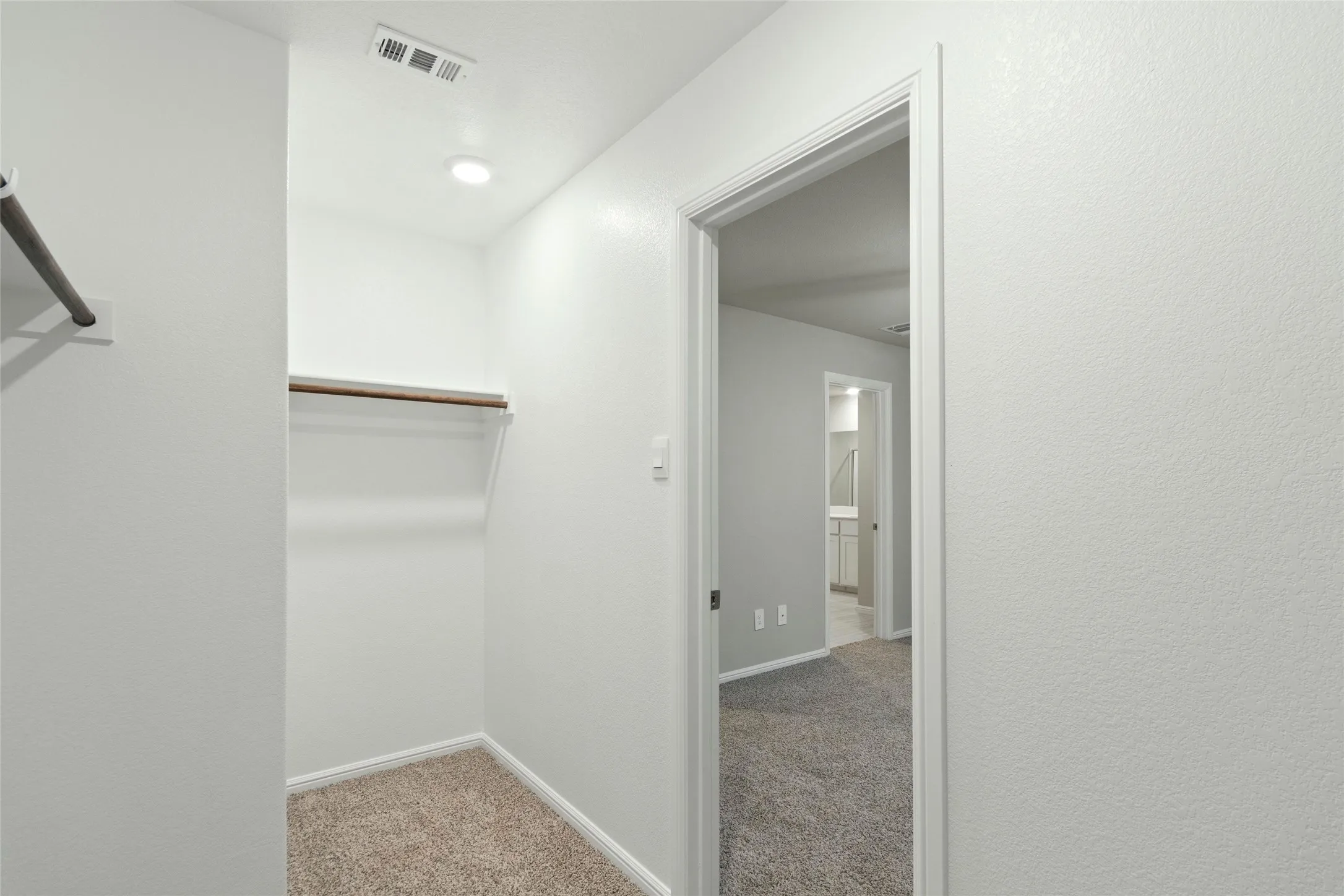 Spacious closet featuring visible vents and carpet