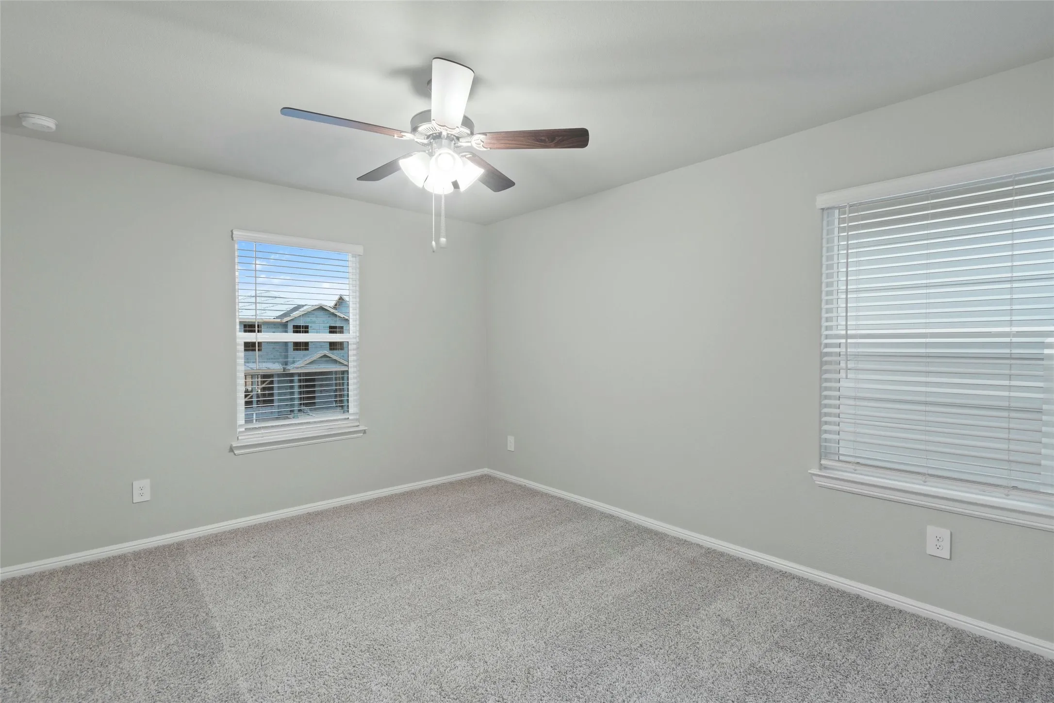 Unfurnished room with ceiling fan, baseboards, and carpet