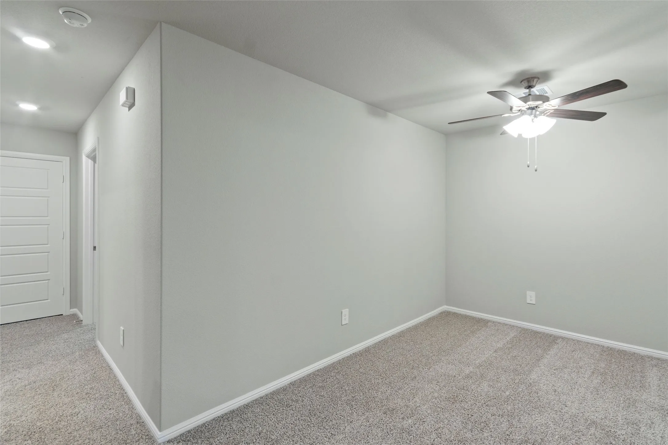 Unfurnished room with light colored carpet, baseboards, and ceiling fan