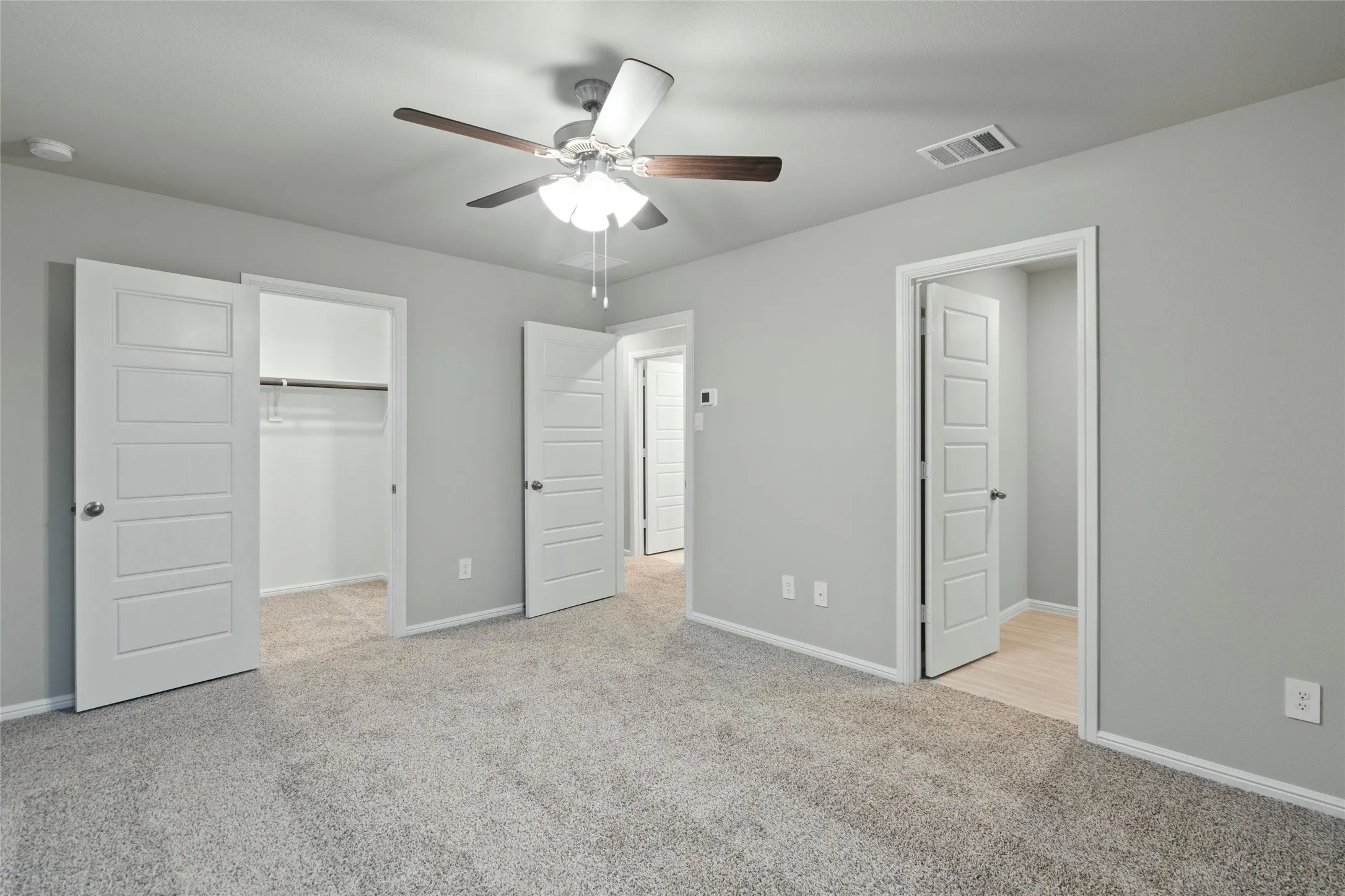 Unfurnished bedroom with visible vents, baseboards, a walk in closet, and carpet
