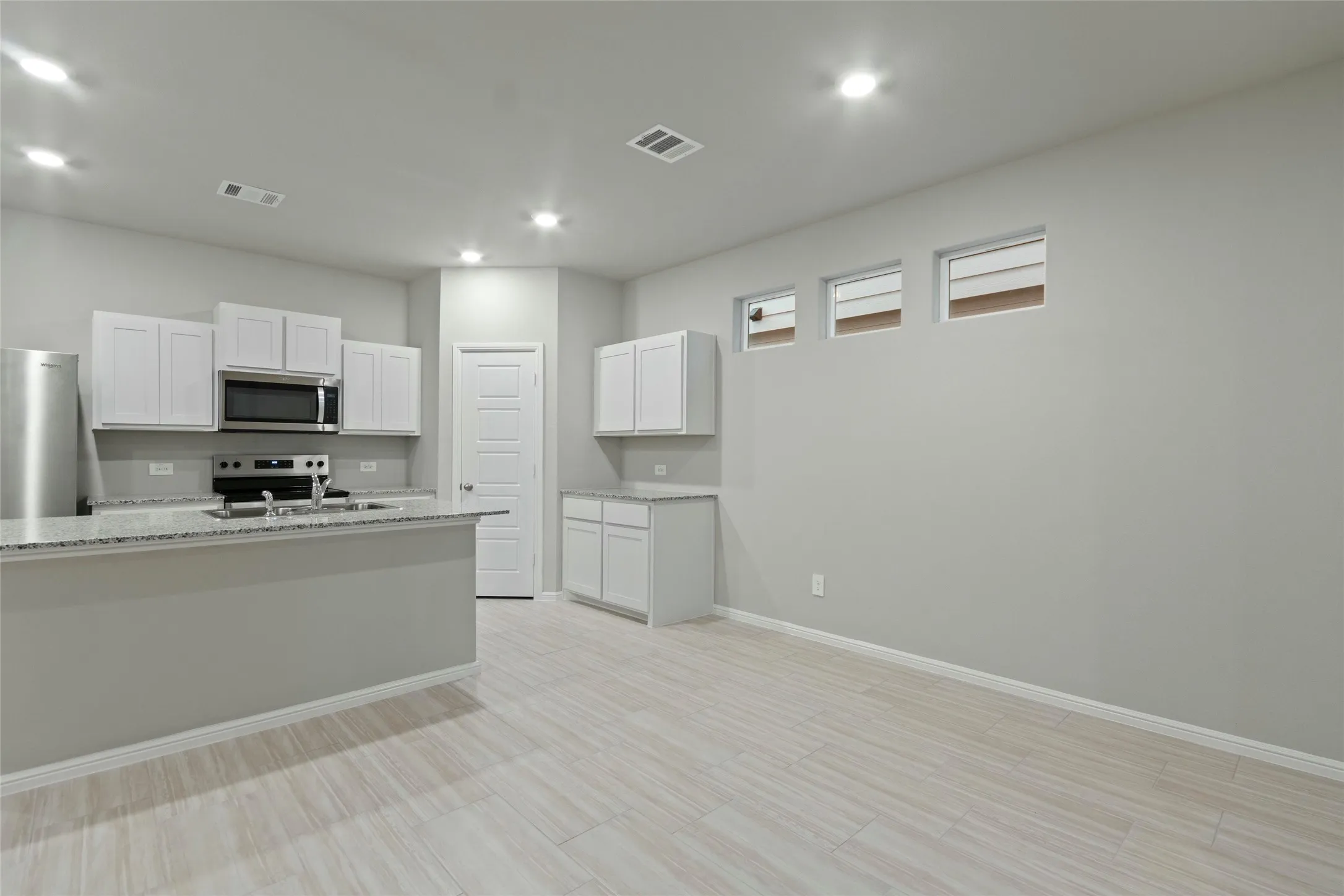 Kitchen with dining area, visible vents, white cabinets, appliances with stainless steel finishes, and baseboards