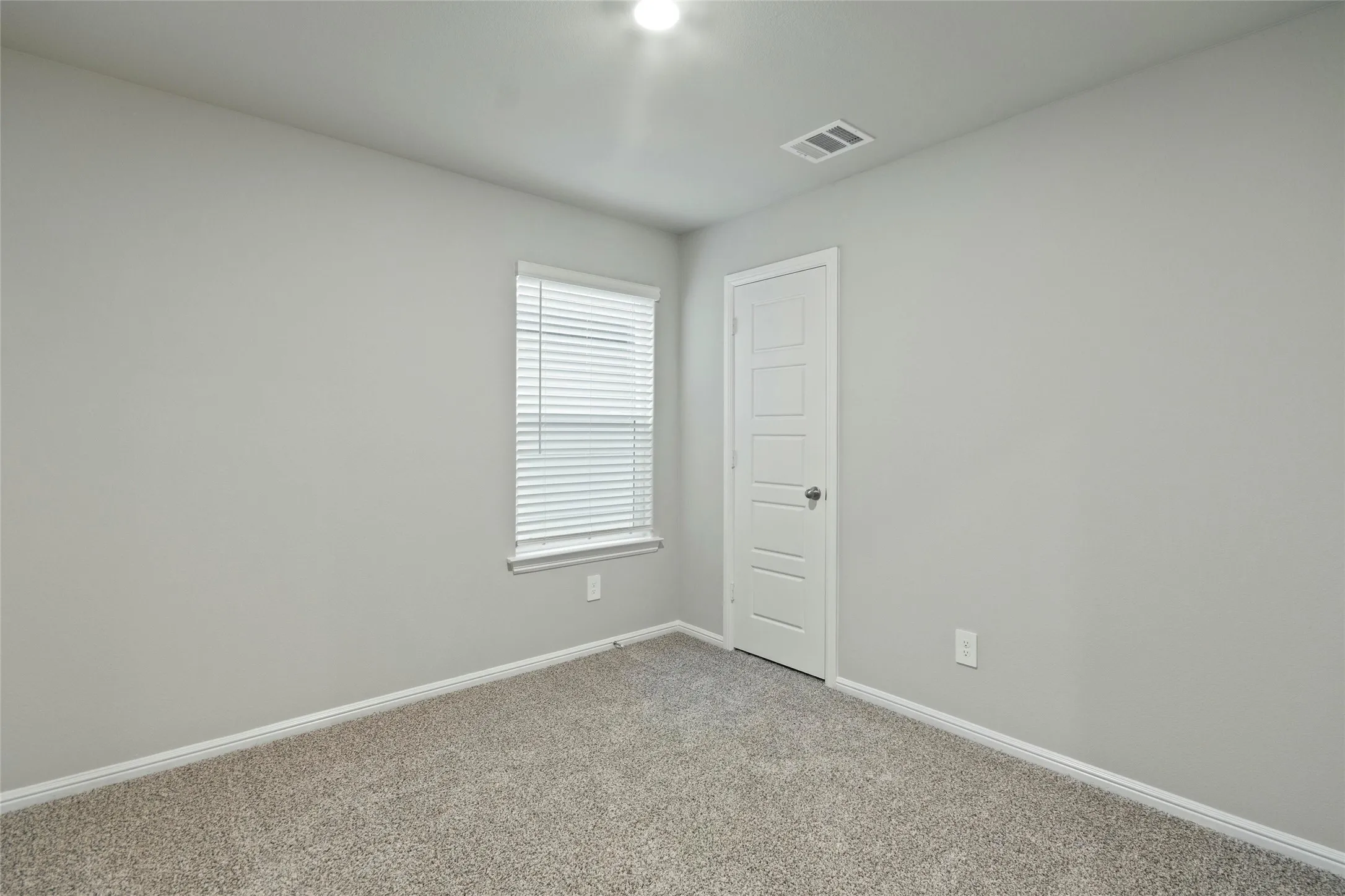 Bedroom with visible vents, baseboards, and light carpet