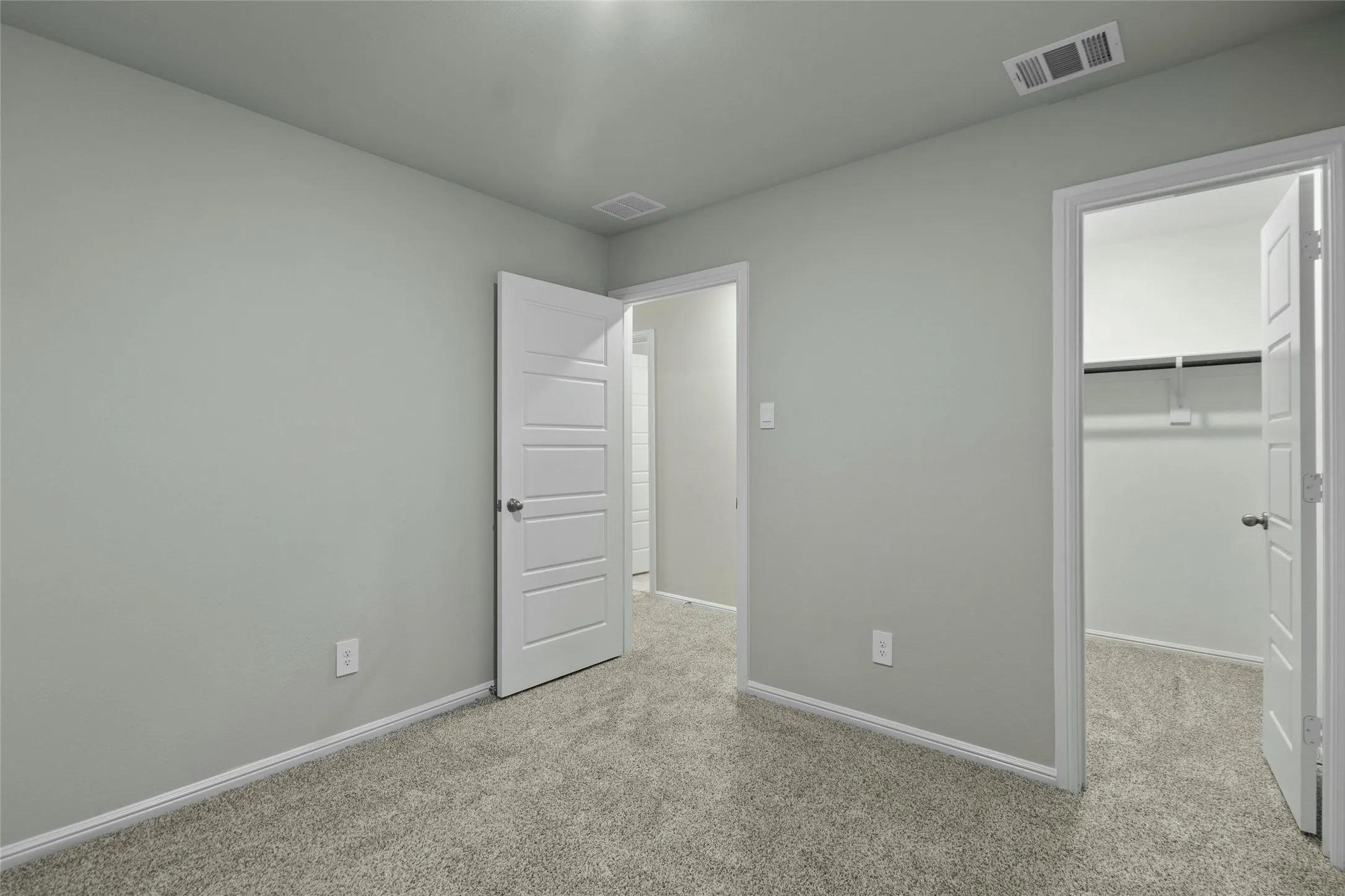 Unfurnished bedroom featuring carpet flooring, baseboards, and visible vents