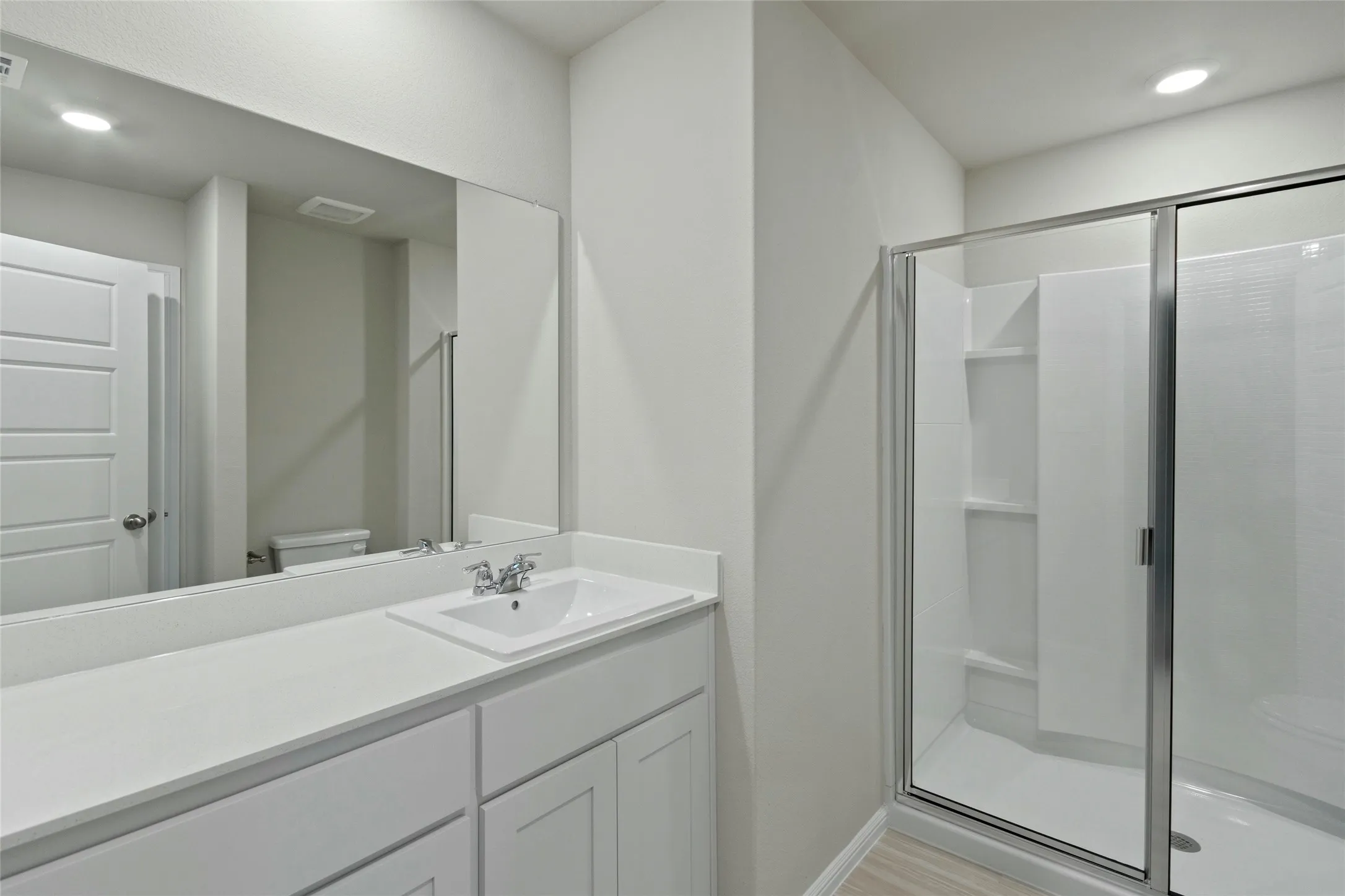 Full bathroom with visible vents, toilet, a stall shower, and vanity