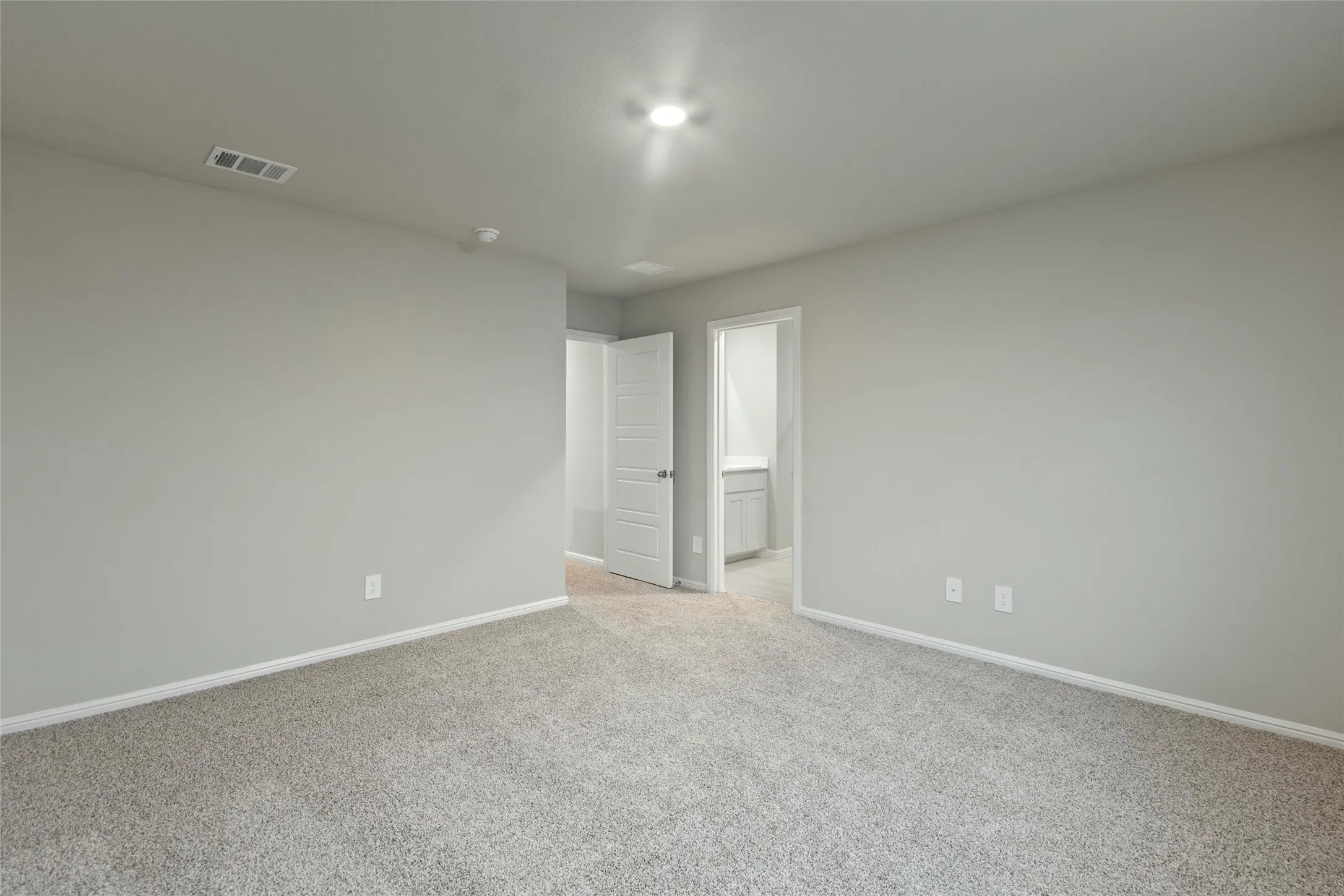 Spare room featuring light carpet, baseboards, and visible vents