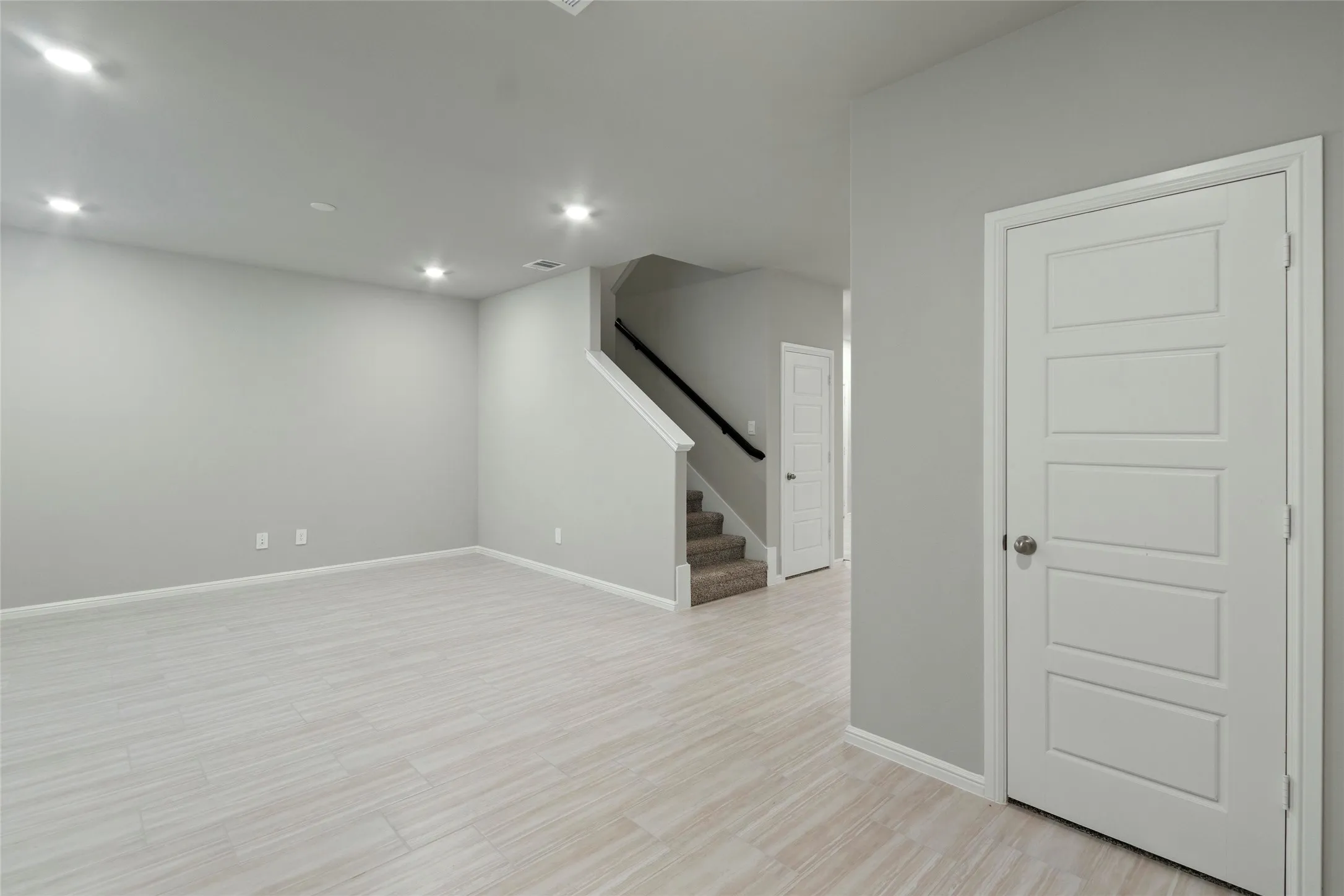 Living room featuring light wood-style flooring, recessed lighting, baseboards, and stairway